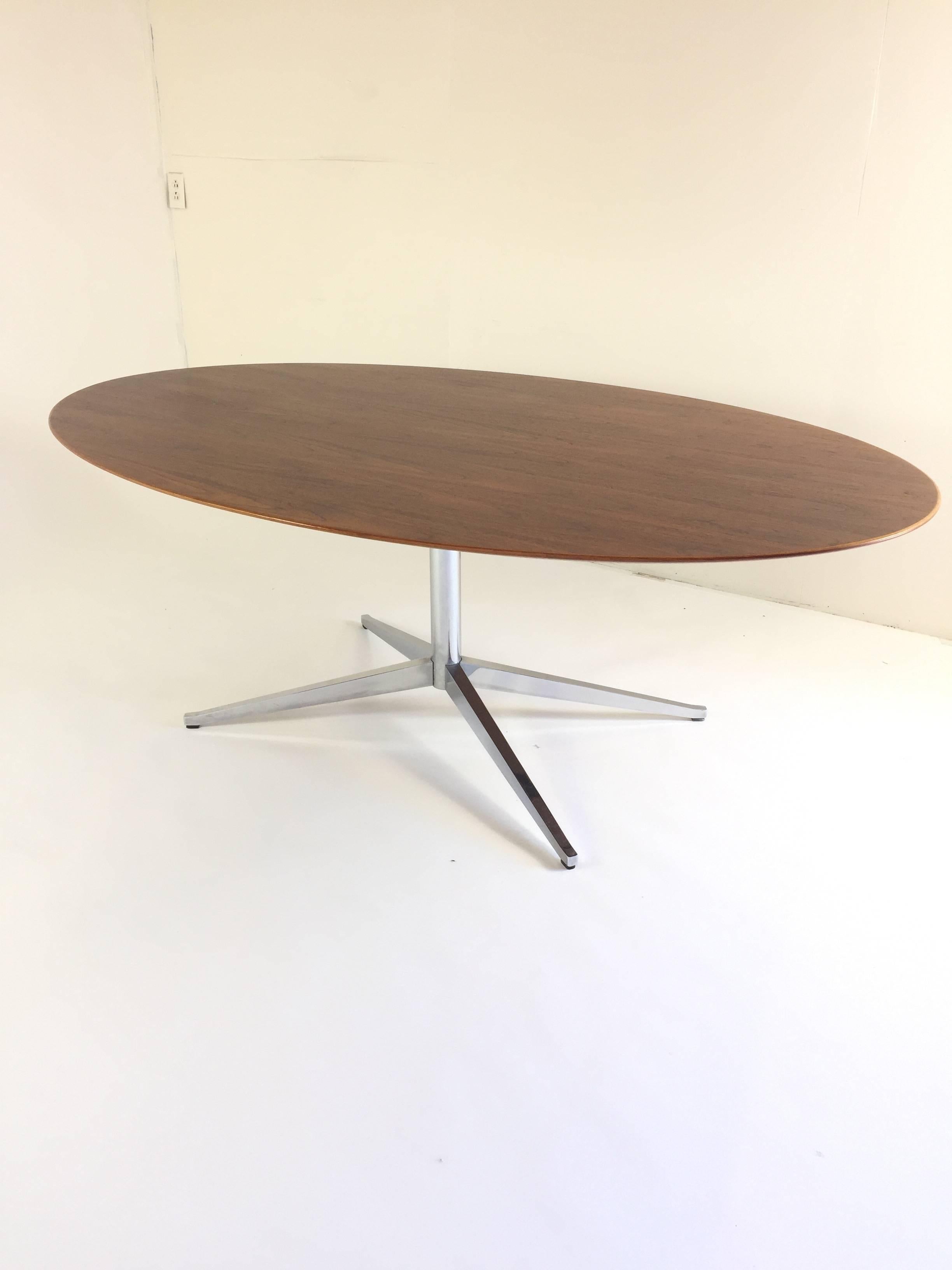 Vintage walnut dining table designed by Florence Knoll for Knoll Associates Incorporated. 
The rich walnut top sits on a beautiful chromed 