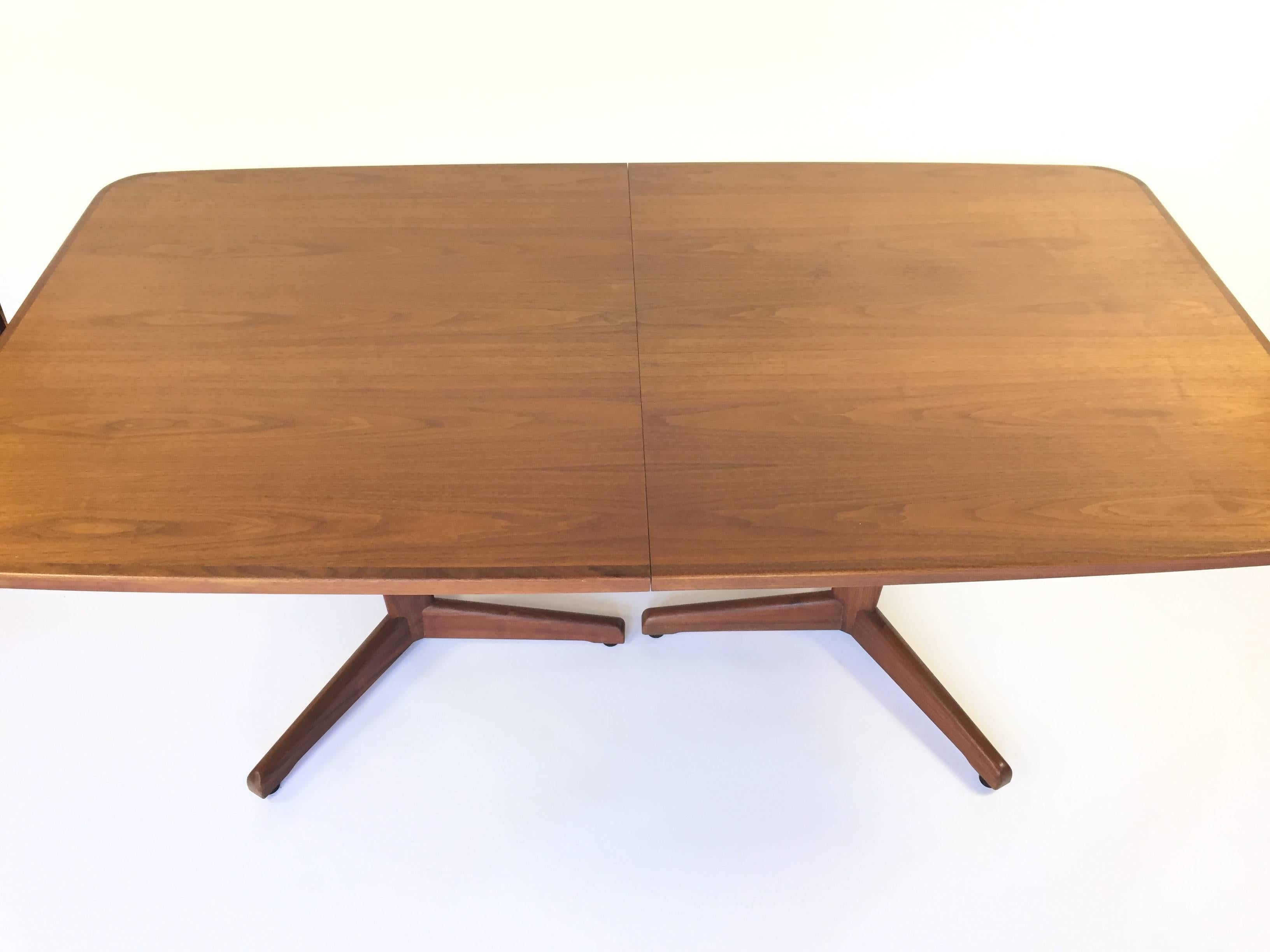 Incredible Mid-Century walnut dining table by John Keal for Brown Saltman. Features tapered legs with unique tripod feet. Includes two leaves of 20