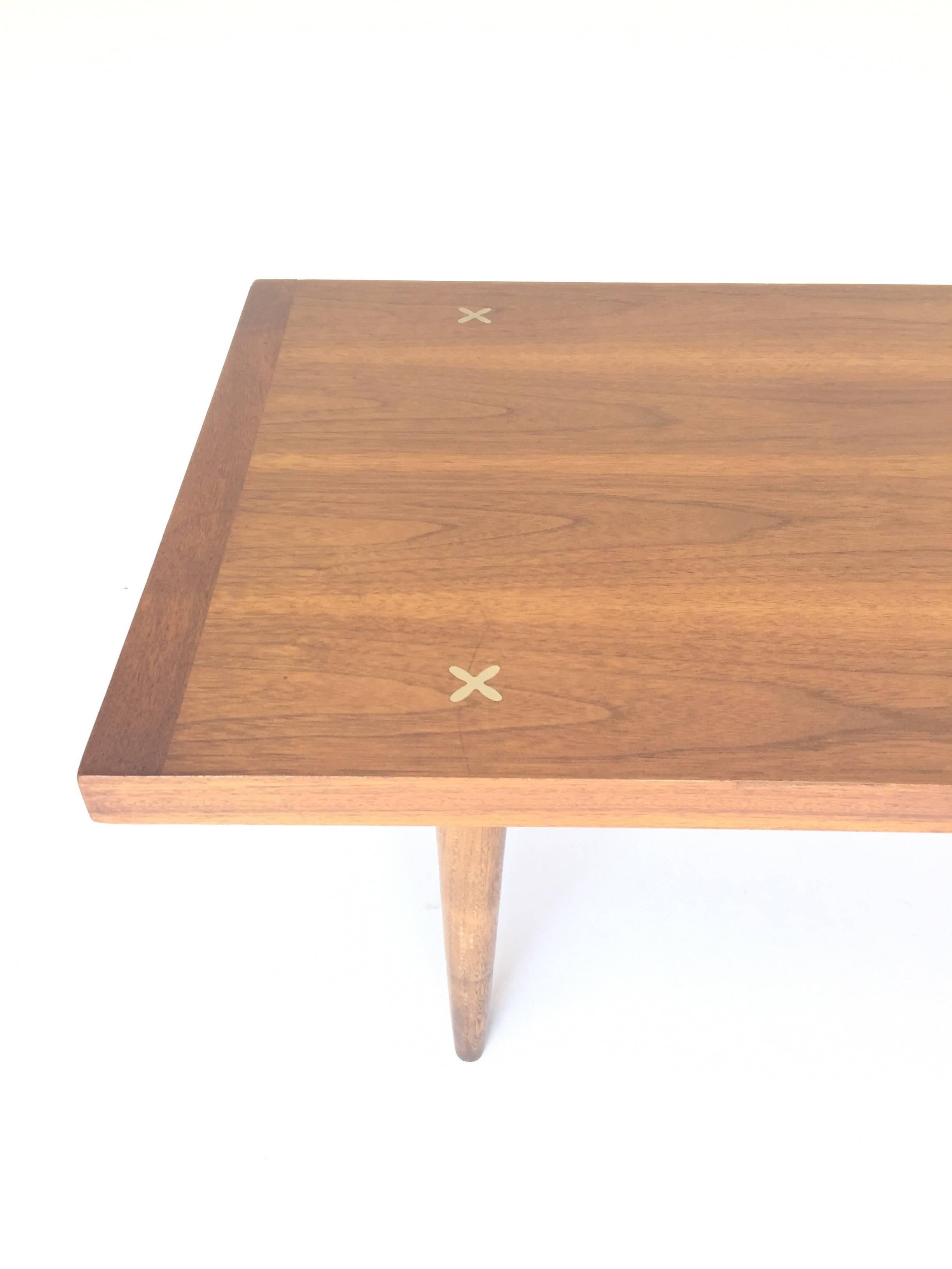 Stylish Mid-Century Modern coffee table by American of Martinsville. Recently refinished walnut grain looks incredible. Features unique X-shaped ornamental inlays in brushed aluminium.