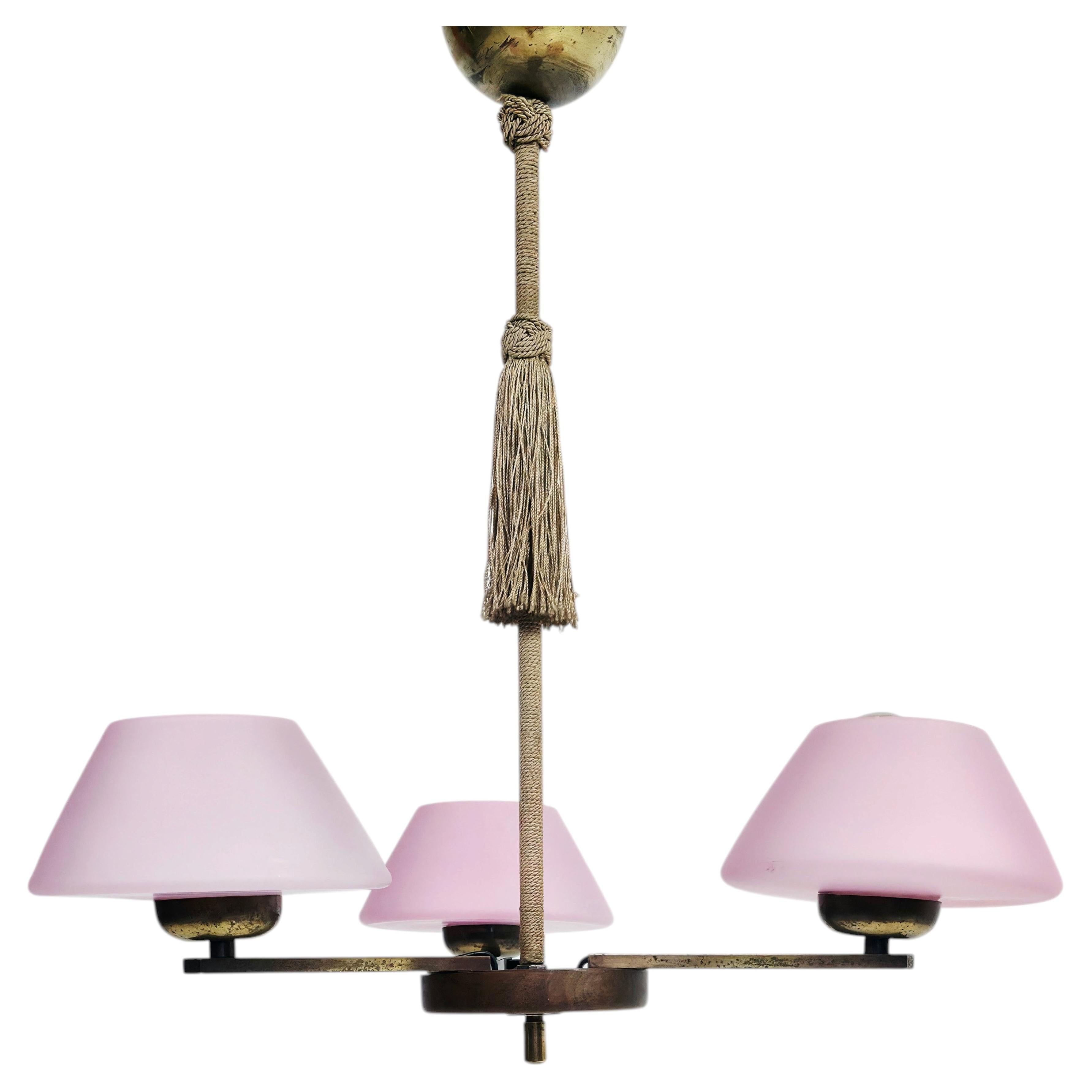 Attribuito a Paavo Tynell – Lampadario a tre bracci con paralumi in vetro rosa