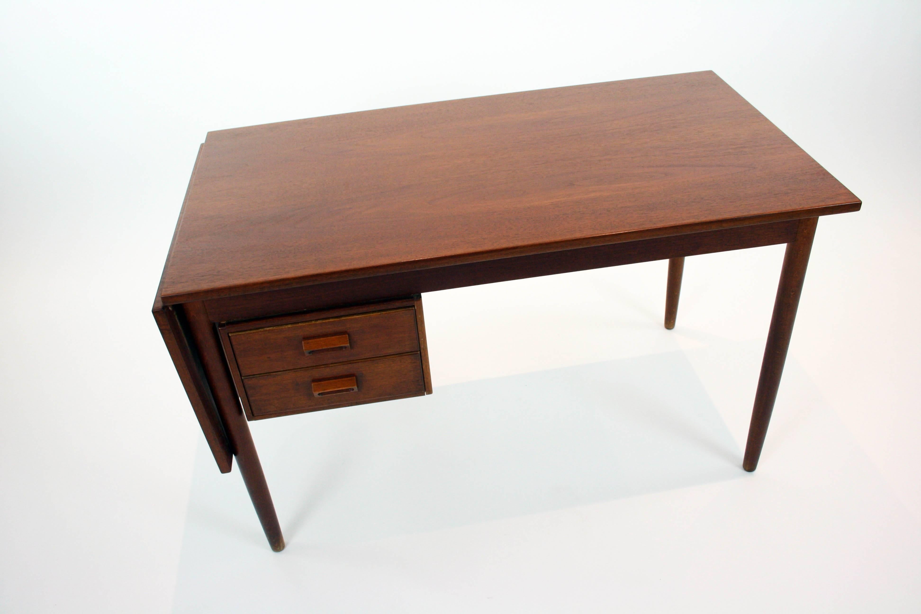 A beautiful Danish teak adjustable desk / work surface. The desk can be manipulated to your needs. The drop-leaf desk top fold up and extends the work surface or stores folded down to conserve space. Also the drawer unit underneath the surface