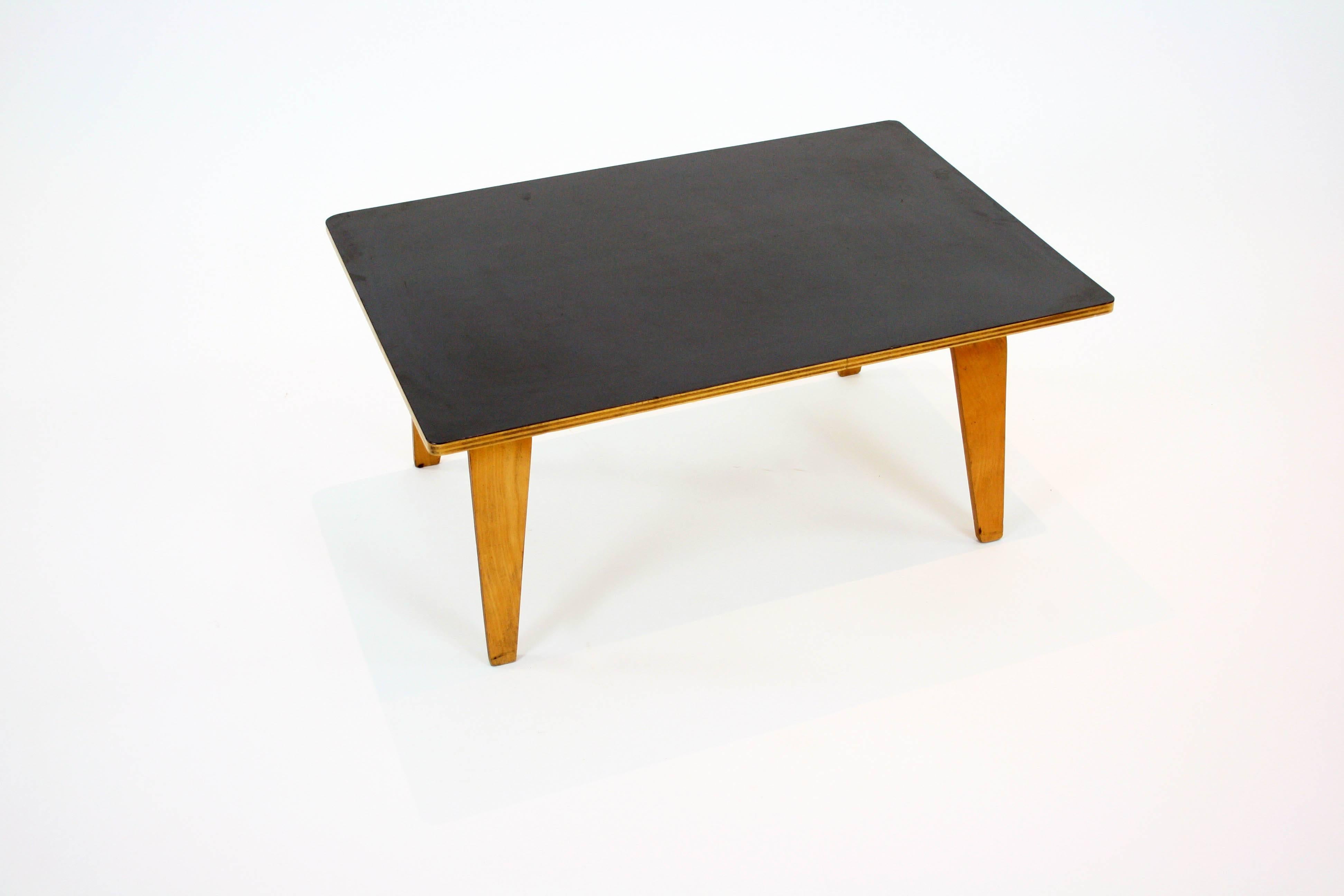 OTW coffee table designed by Charles and Ray Eames with black top. Designed by Charles and Ray Eames in 1946, the 