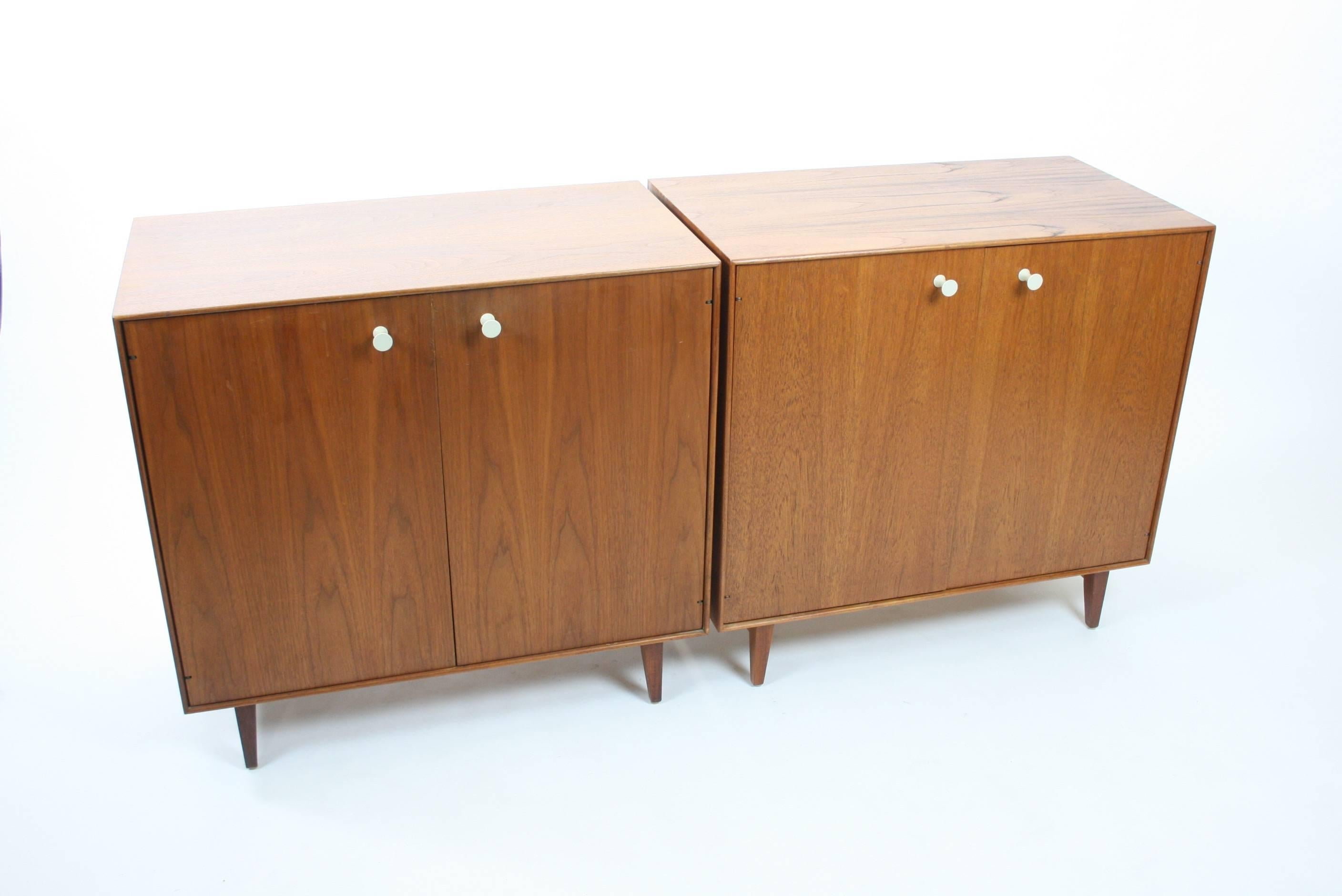 Rare pair. One is walnut (left) and one is teak (right). Both have been completely restored and show off beautifully! Retain original porcelain pulls and uncommon walnut legs. These are harder to find than the aluminum type thin edge legs. Inside of