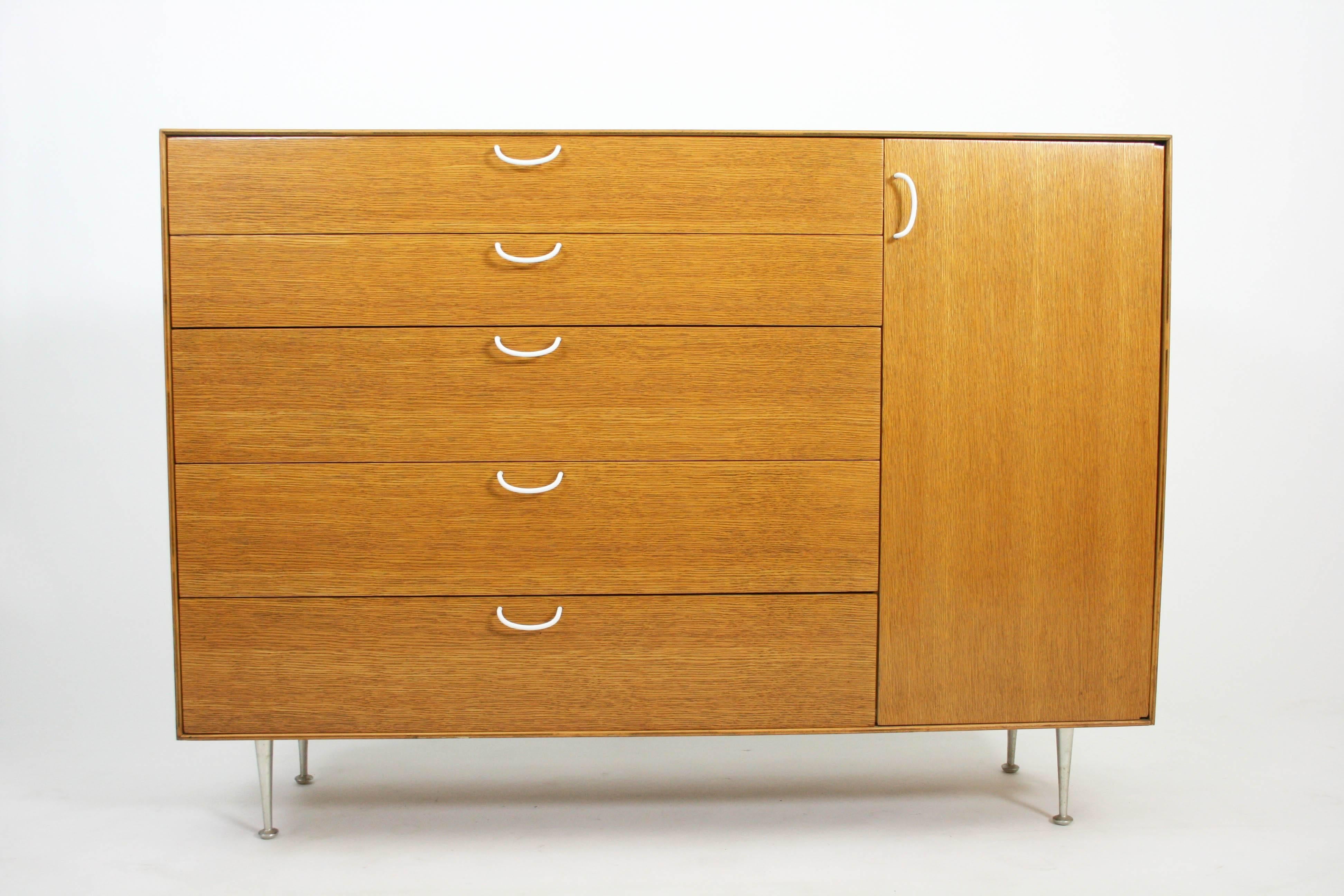 Rare combed oak thin edge George Nelson cabinet for Herman Miller. This cabinet is very rare and was only in production for less than one year. It has unique wire rod pulls which were exclusive to this line. Lots of drawers and storage on this