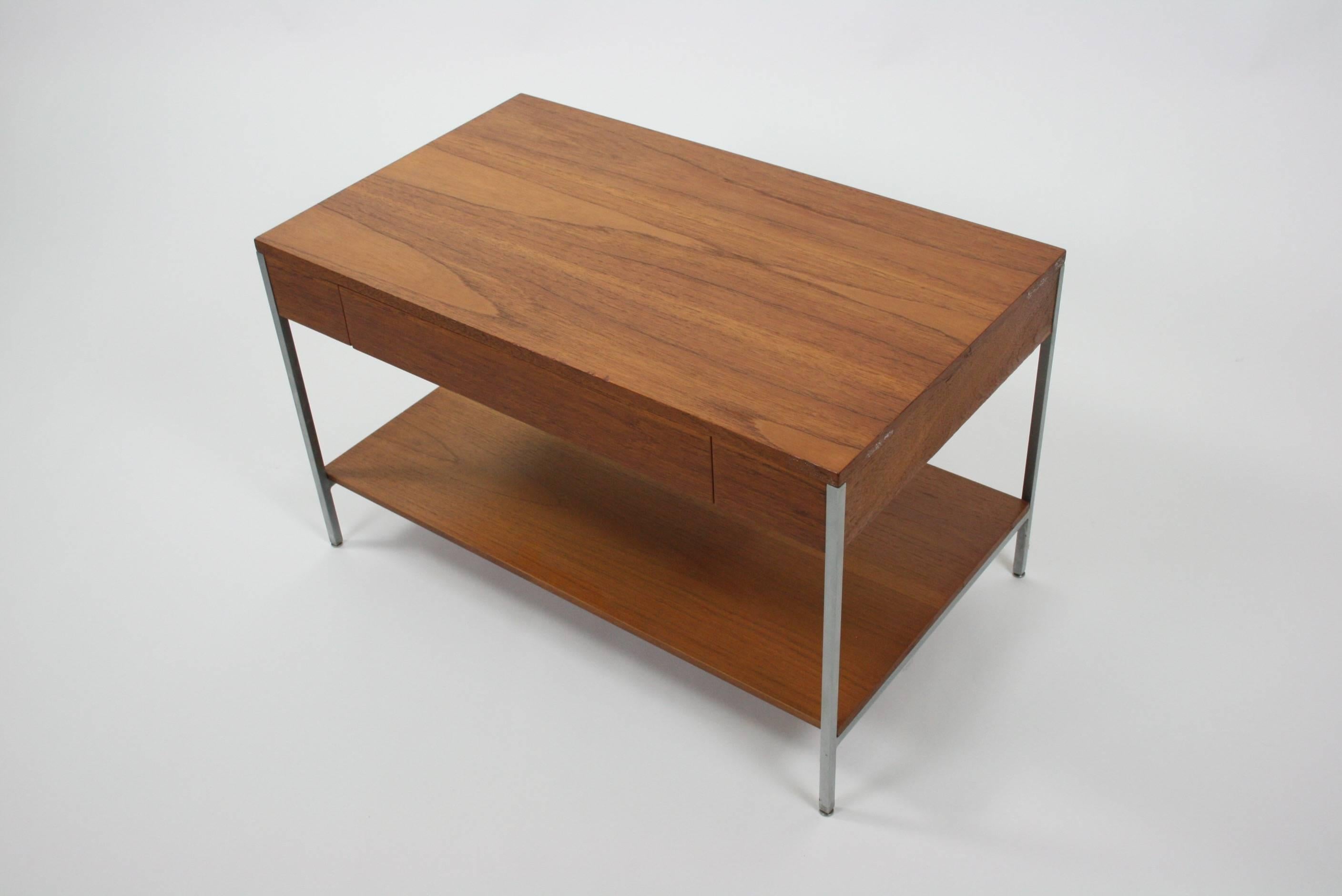 Exceptional all original finish side table with a drawer and laminated slide out tray table. The walnut case is held floating by a simple and subtle brushed steel frame. A shelf below for more storage. All original condition. Self leveling feet at