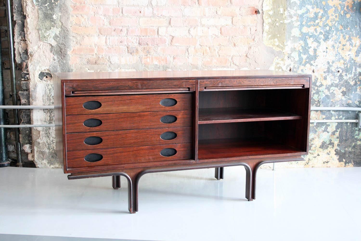Small rosewood sideboard by Gianfranco Frattini for Bernini Italy
Rosewood sideboard with tambour doors designed in 1957 by Gianfranco Frattini for Bernini, Italy. Two spaces with internal drawers on left and shelves on the right. Two available.