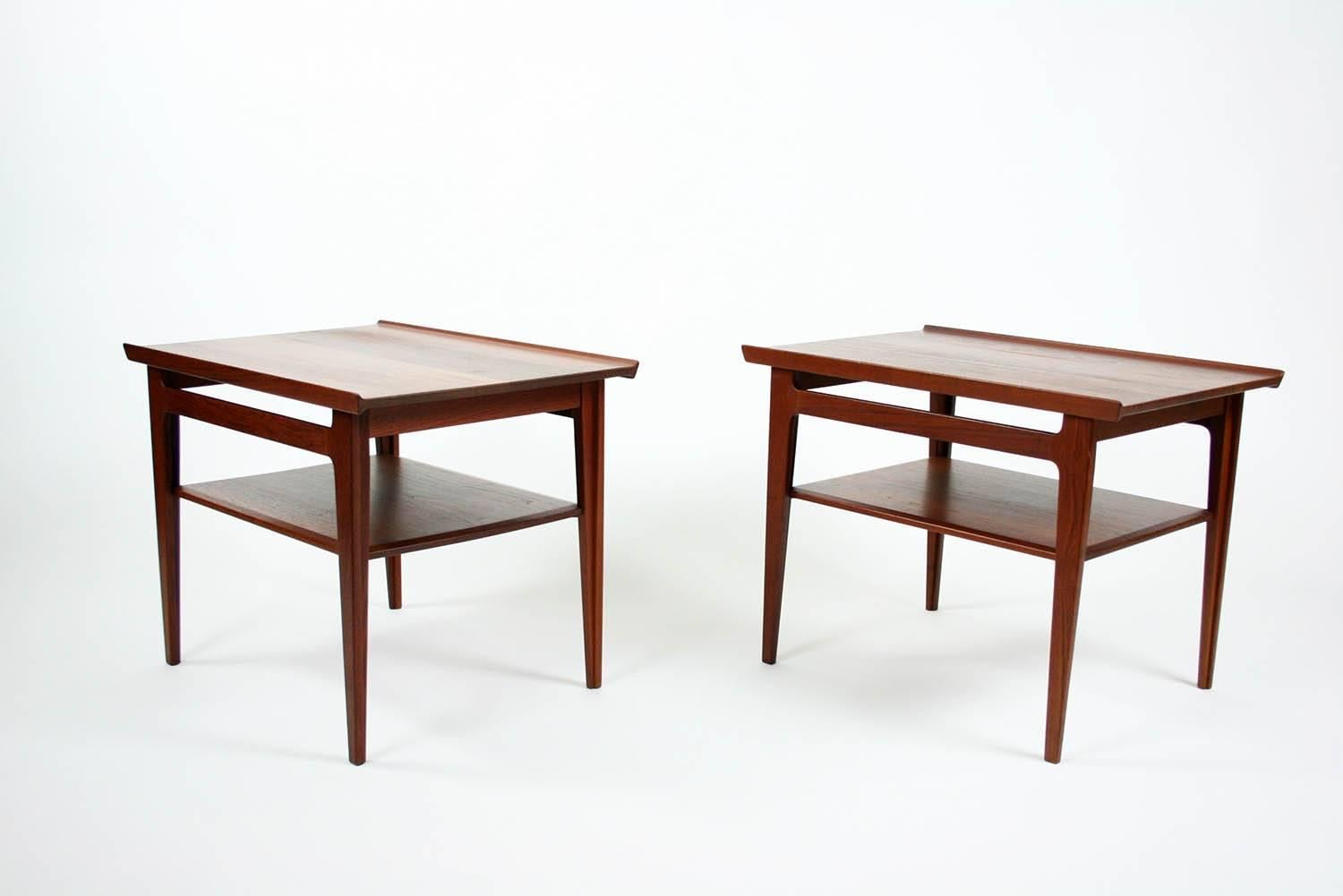 Pair of 500 series Danish teak tiered side tables by Finn Juhl for France and Son. Tables are rare solid teak. Sleek design, perfect Danish details and construction.