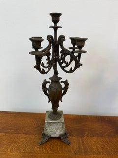 Coppia di candelabri antichi in bronzo a cinque bracci su basi in marmo