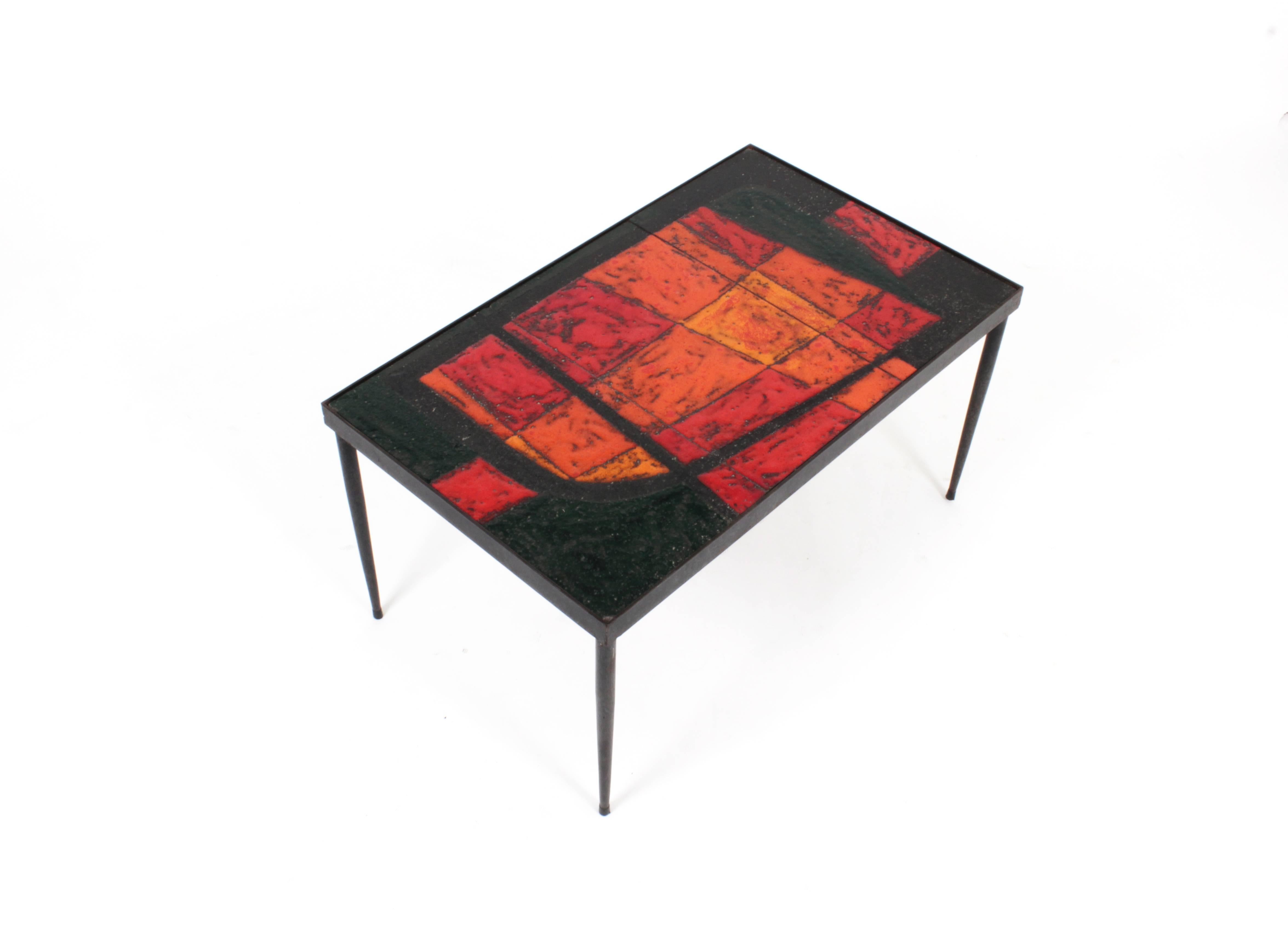 Beautiful abstract composition for this low table made by the French ceramists brothers Robert and Jean Cloutier, circa 1960.
Enameled lava in bright red and orange, and dark green, on a black lacquered metal structure. Intense colors and