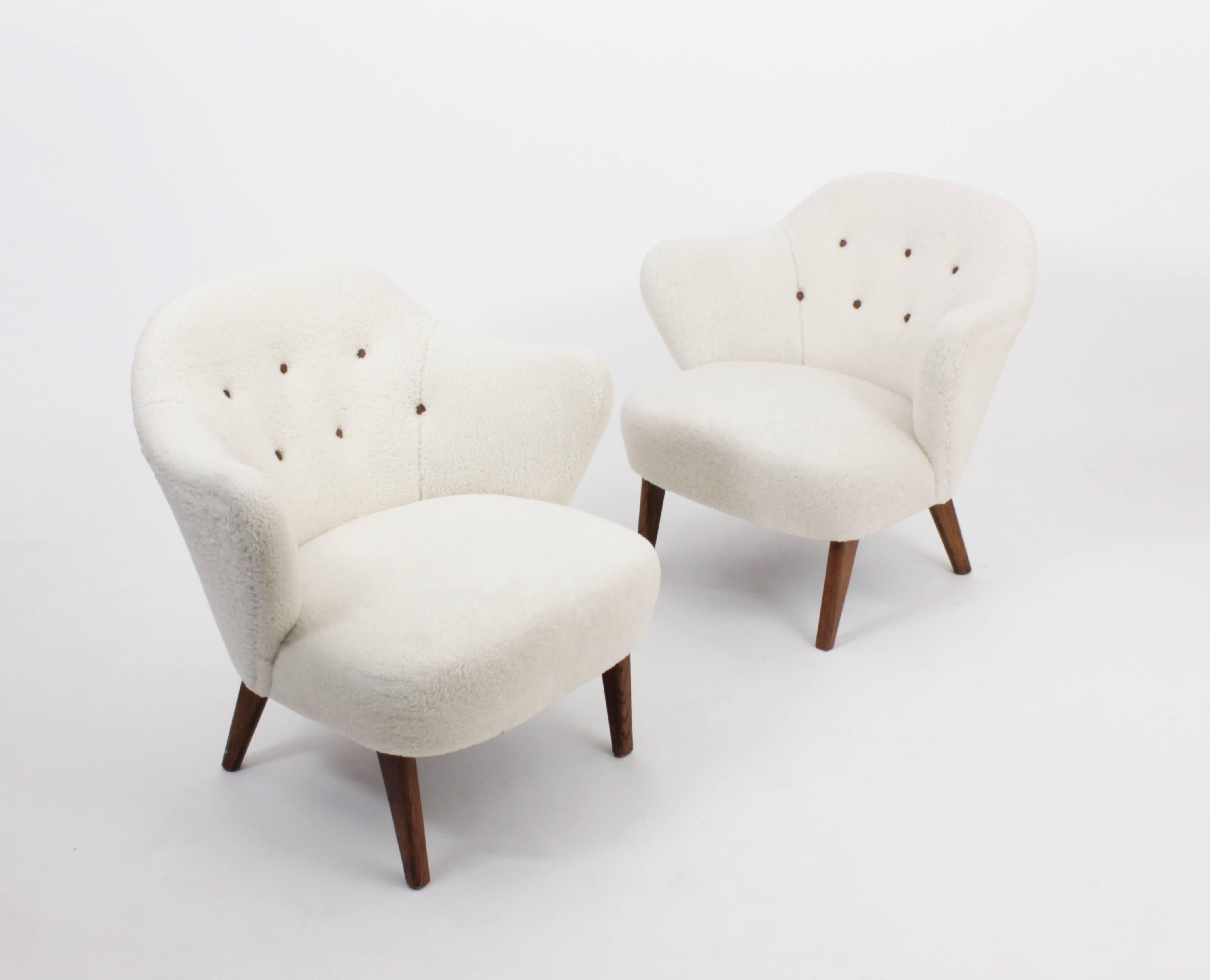 Rare pair of easy chairs designed in Denmark in 1940 by Flemming Lassen and made by Jacob Kjaer.

Beech legs and curly lambskin.

Exhibited at The Copenhagen cabinetmakers' guild exhibition, Design museum Denmark in 1940.
Literature: Grethe