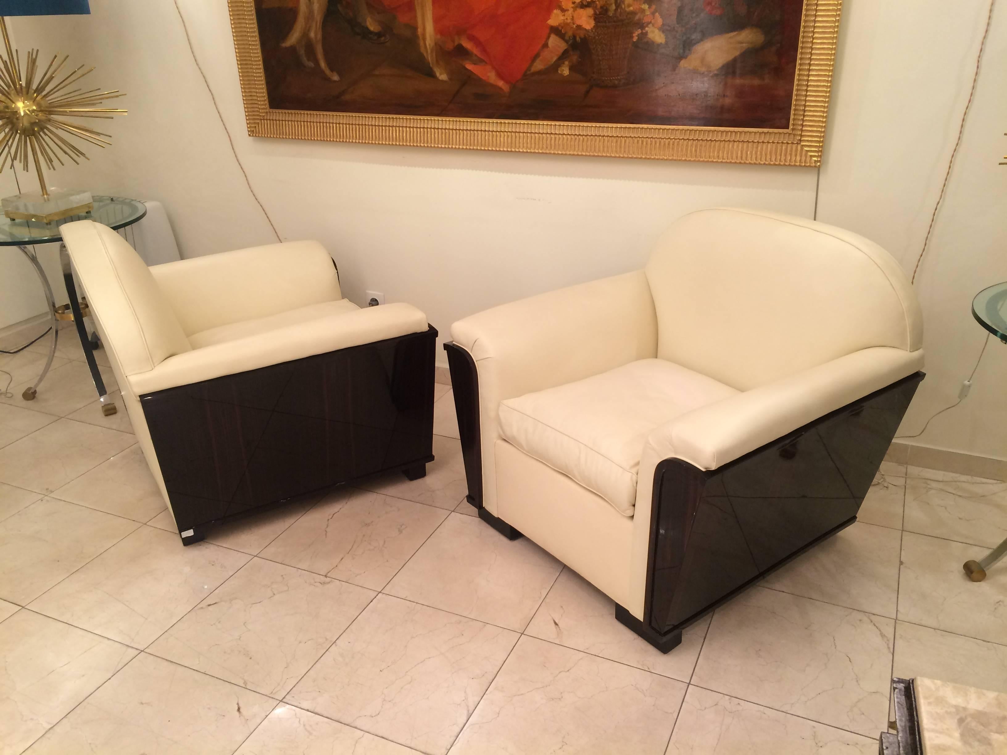 Elegant pair of Art Deco big armchairs in Macassar wood and upholstered in a 
crème leather,
France, circa 1930.