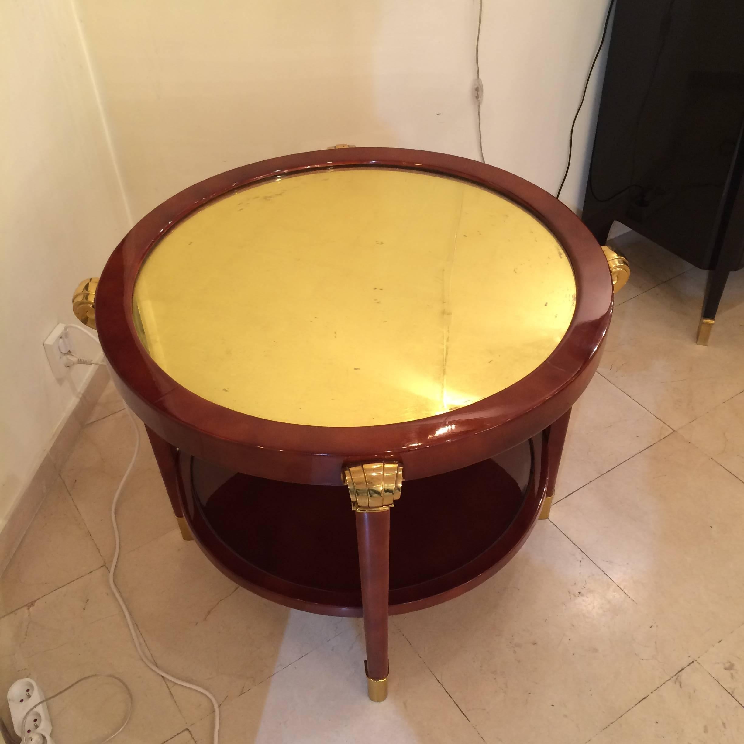 Very chic Art Deco table in light brown lacquer, 
the top is in gold leaf mirror.
Big decorative elements in massive bronze.