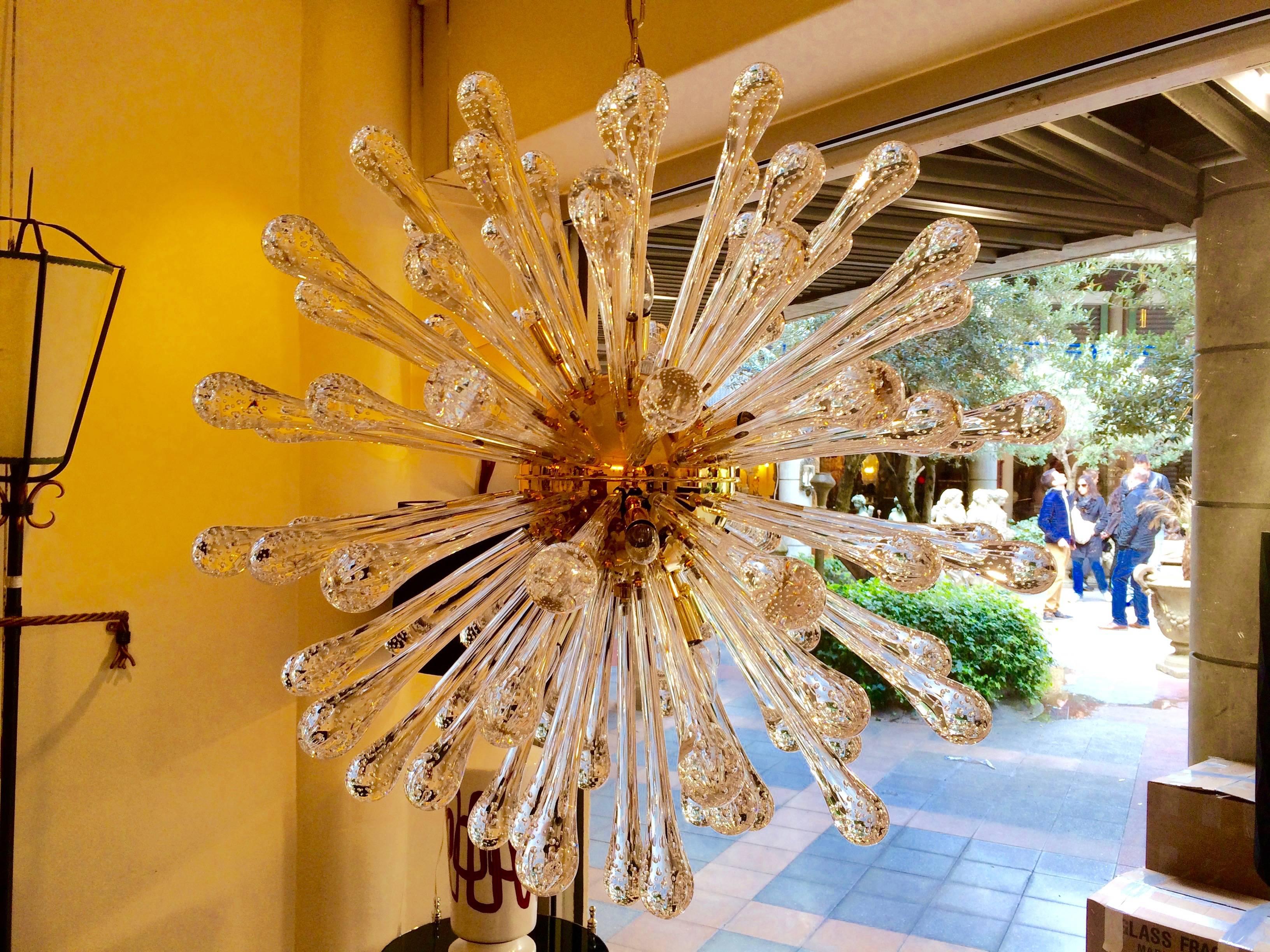 Sunburst chandelier in Murano glass, the round structure in gold plated.
16 lights.