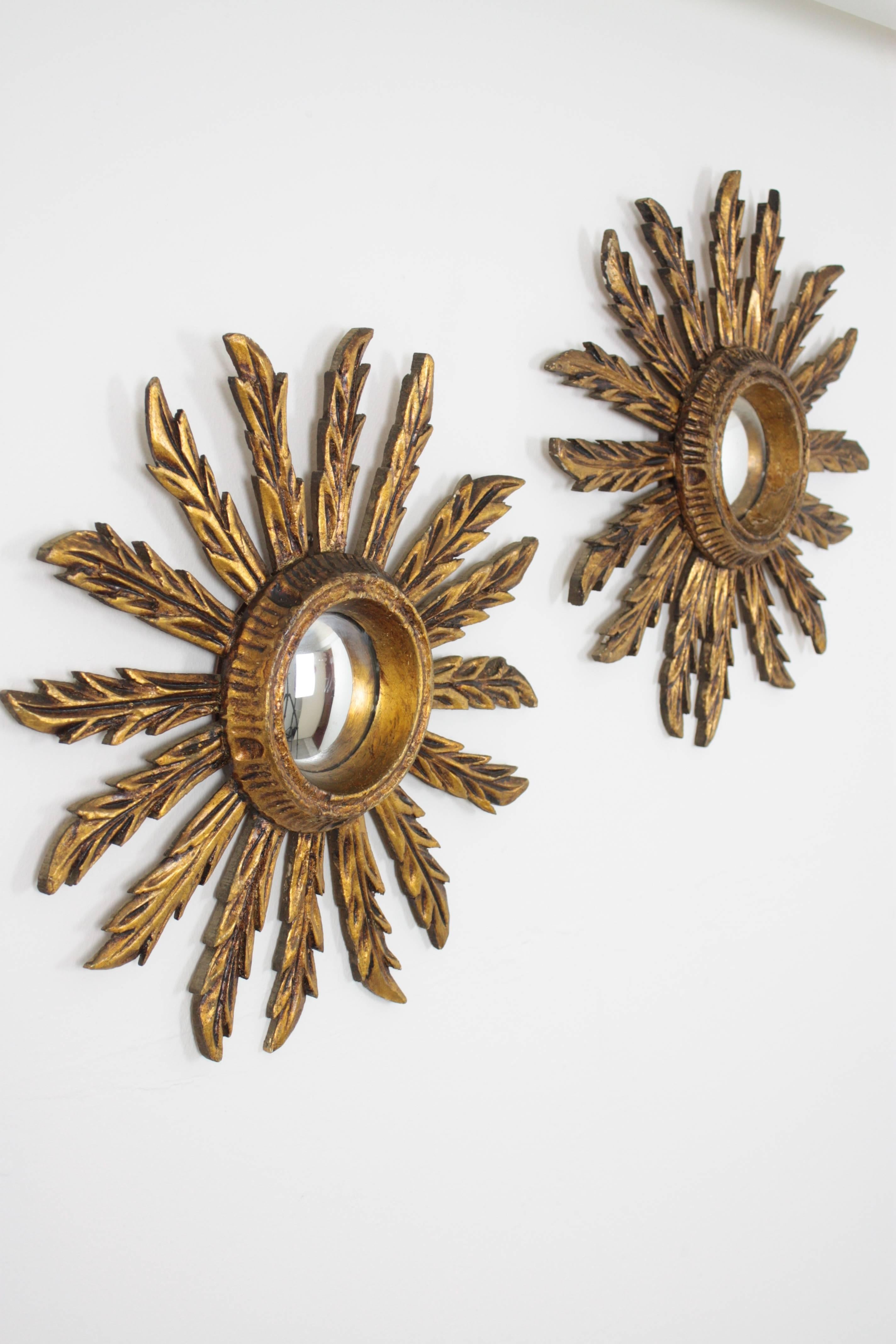 Beautiful pair of sunburst mirrors in this unusual mini size in Baroque style. Carved wood covered with gesso and gold leaf finish. Lovely vintage patina. Both of them wear the original convex glass mirror. Dimensions of the glass: 8.5 cm
