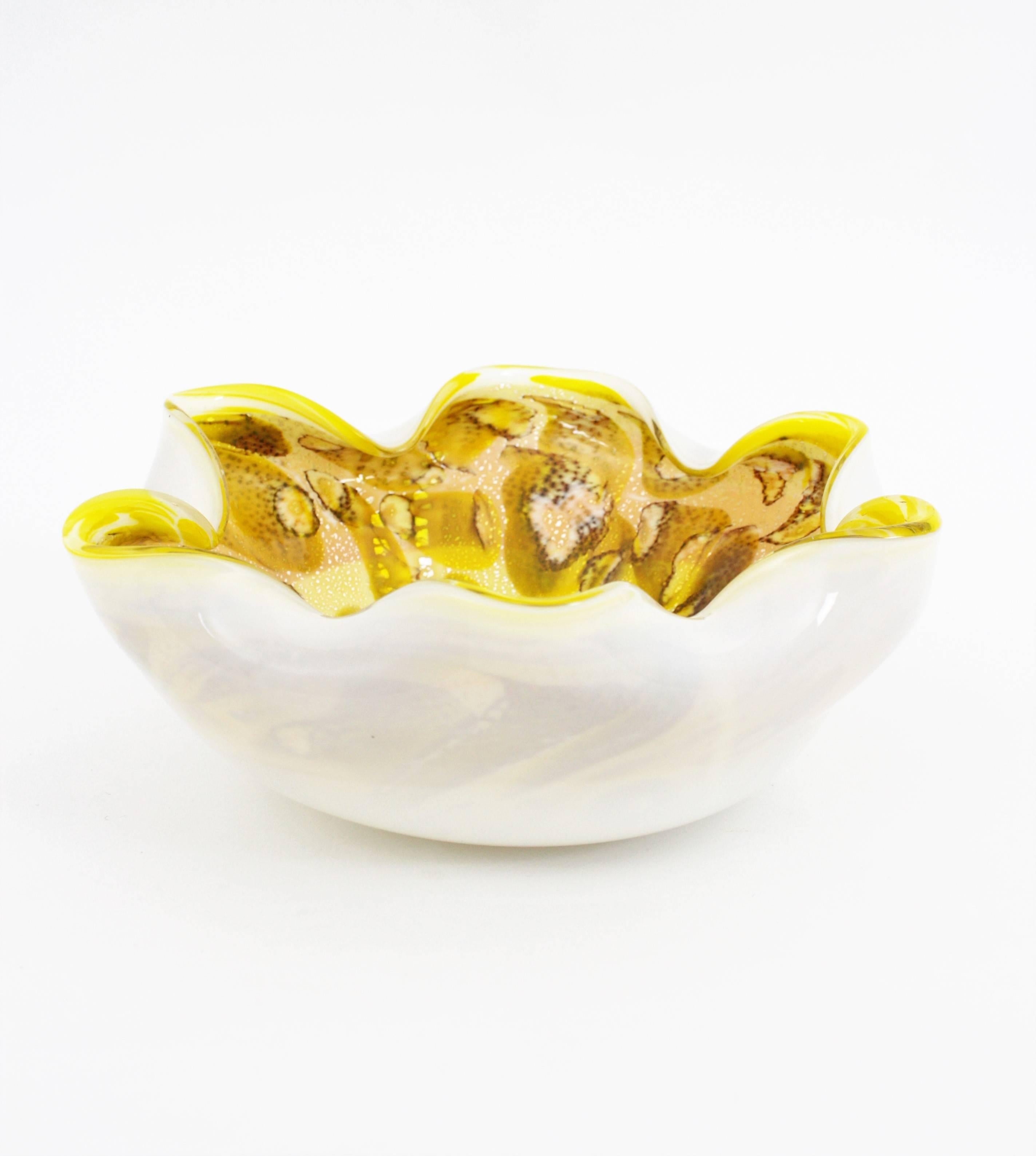 A monumental hand blown flower shaped Murano art glass bowl or centerpiece in yellow tones with interior murrine decorations and print animal accents. It has aventurine silver and gold flecks and the exterior part is made in white opalescent glass.