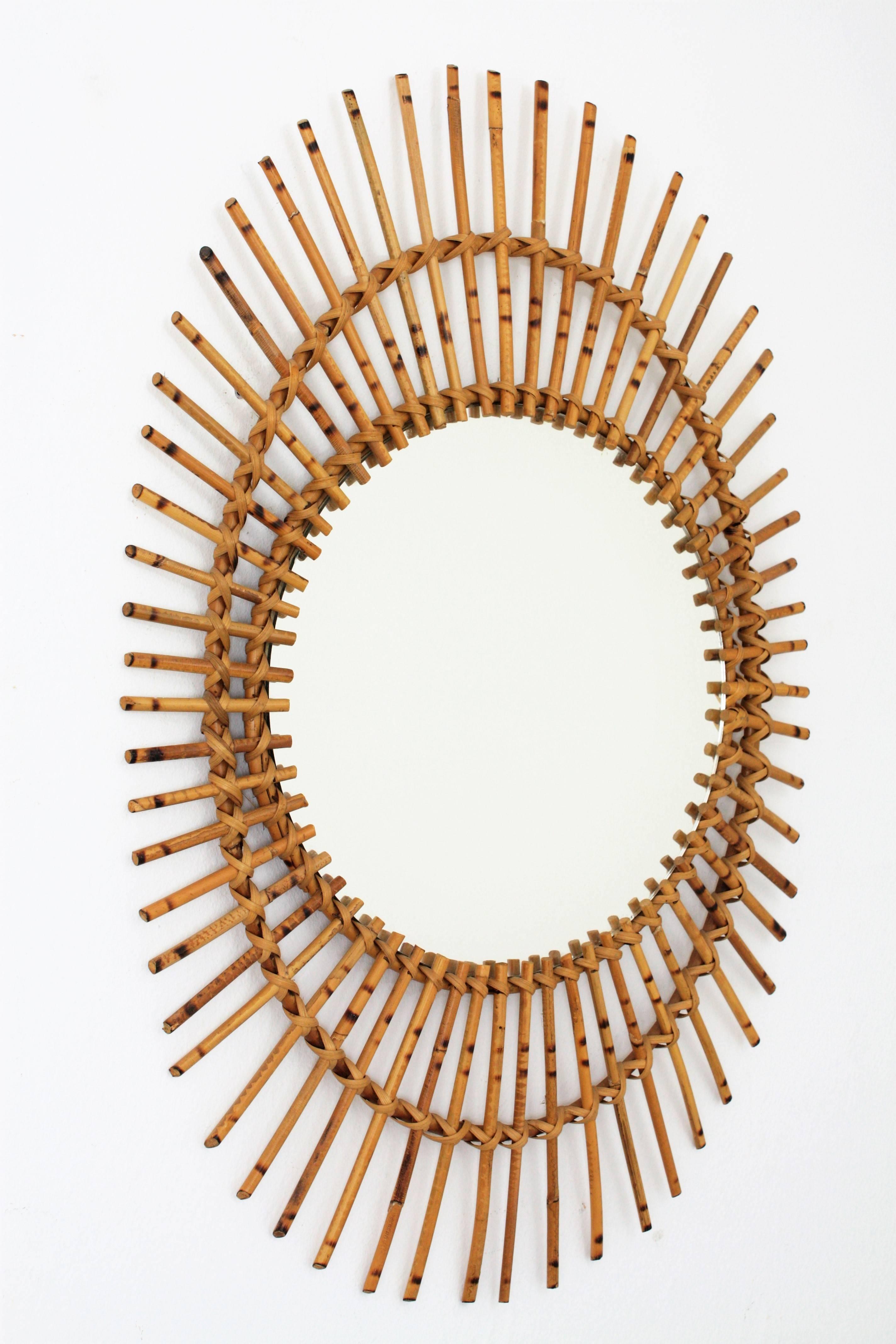 Beautiful midcentury rattan or wicker oval shaped asymmetric sunburst mirror. This piece has all the taste of the Mediterranean coast style and it is in excellent vintage condition. France, 1960s.
Beautiful to place in a wall decoration with other