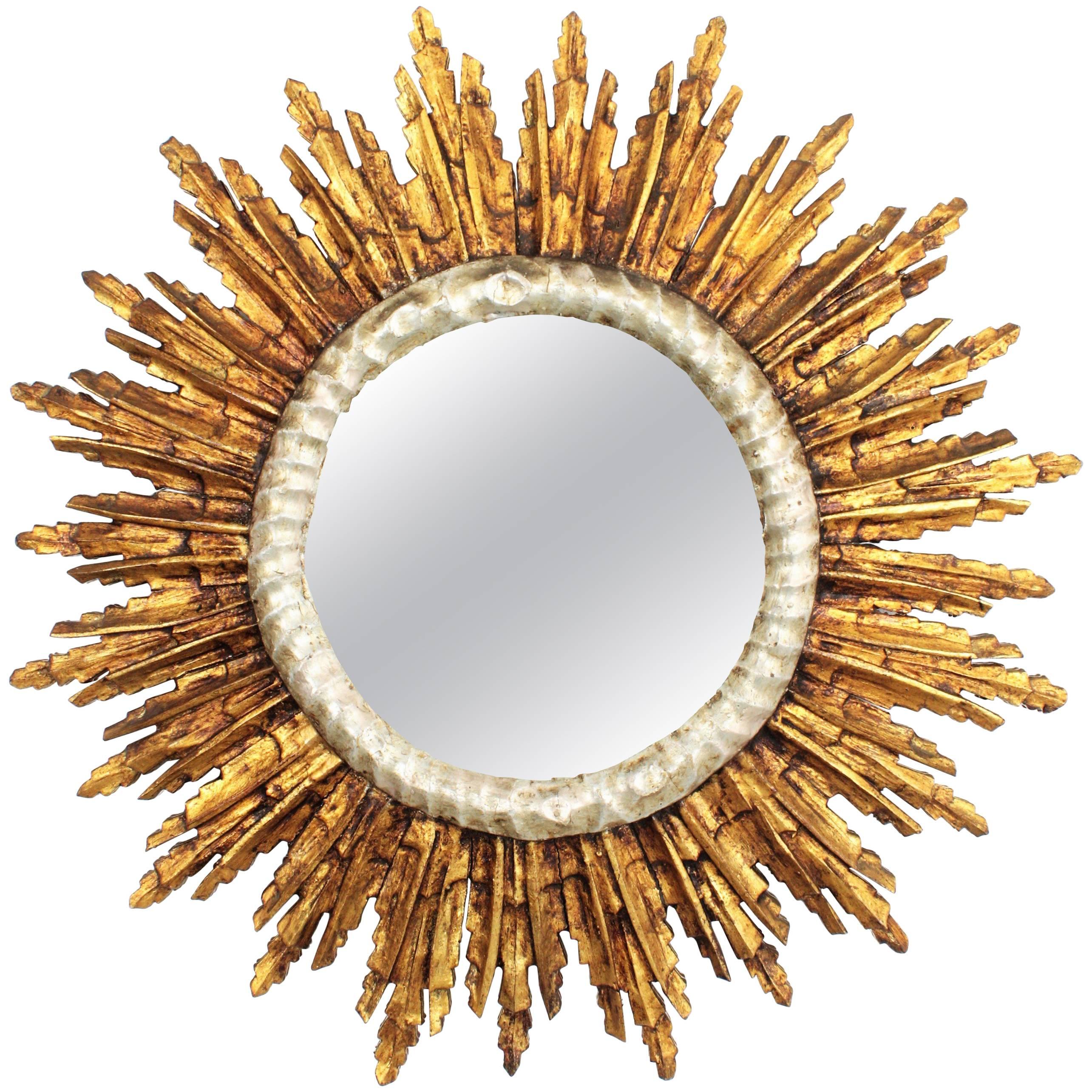 Magnificent hand carved wood mirror in Baroque style with silver leaf finish surrounding the glass and gold leaf finish at the frame. France, 1930s.
The mirror has a gorgeous patina and it is in excellent condition, 
Overall diameter: 70