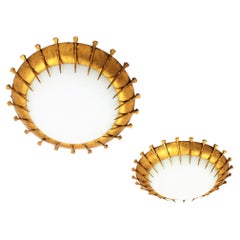 Paar französische Sonnenschliff-Leuchten aus vergoldetem Eisen und Milchglas mit Nägelakzenten