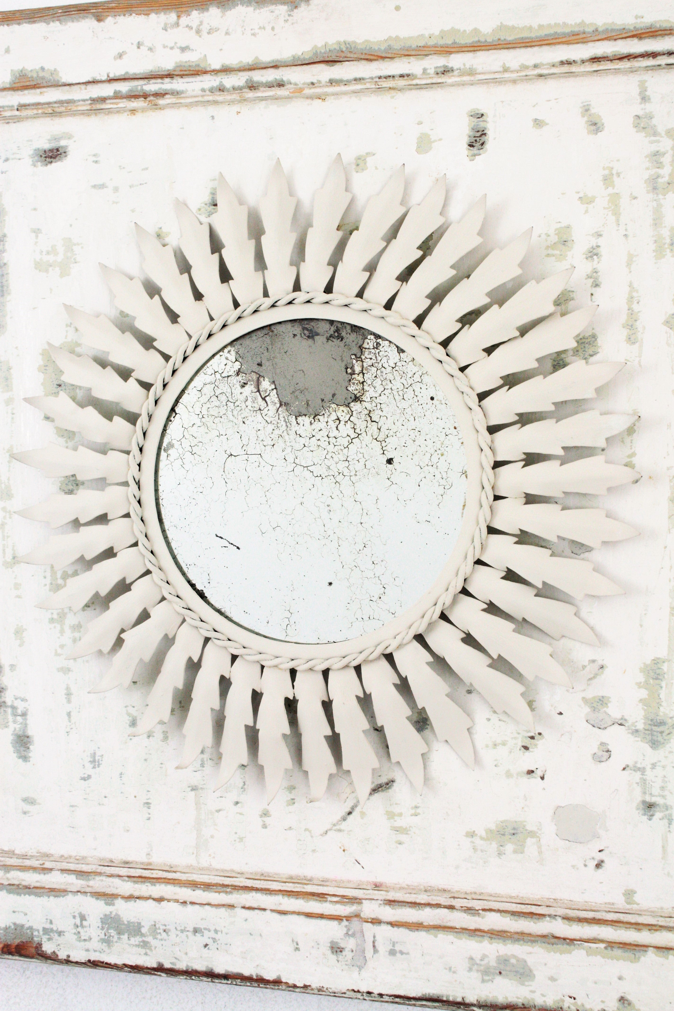 Eye-catching Trumeau mirror composition with a white patinated sunburst mirror framed by an antique painted door, Spain, 1960s
The door has its original painting and a nice aged patina showing different coats of paint.
This wall mirror will be a