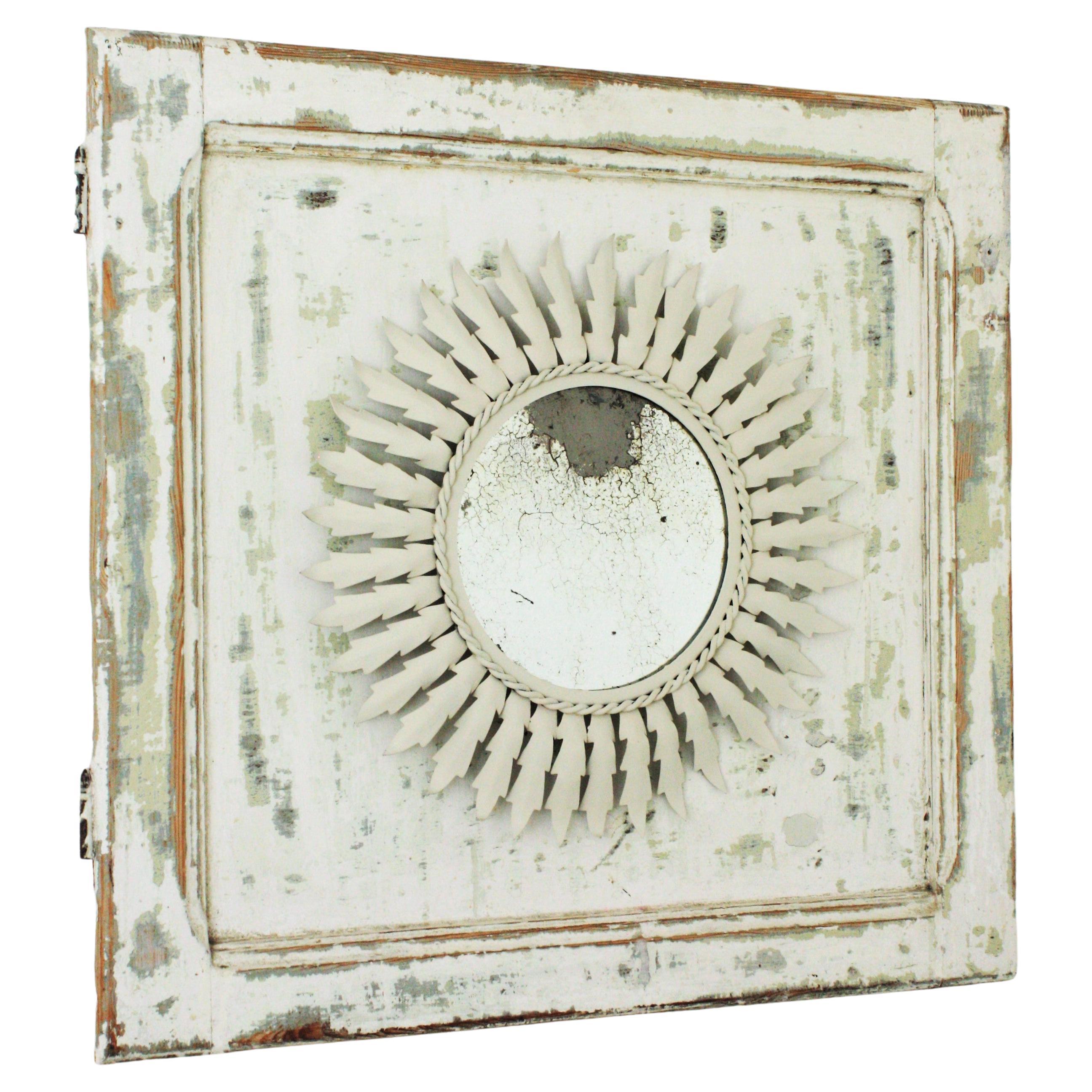 Sunburst-Spiegel aus weißem Metall, umrahmt von einer patinierten Holztür