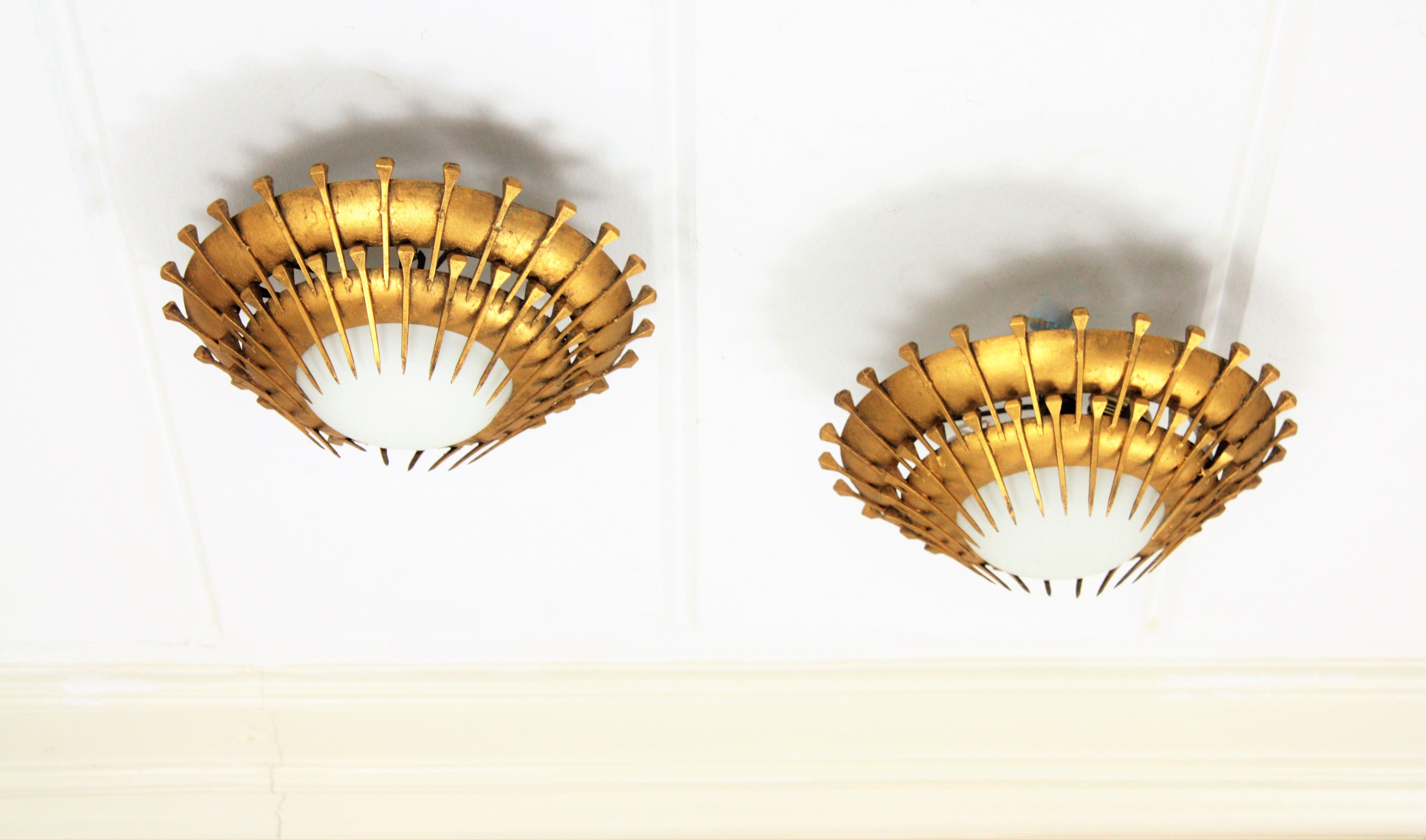 Pareja de lámparas empotradas con diseño de clavos de sol, hierro dorado, cristal de leche Francés en venta