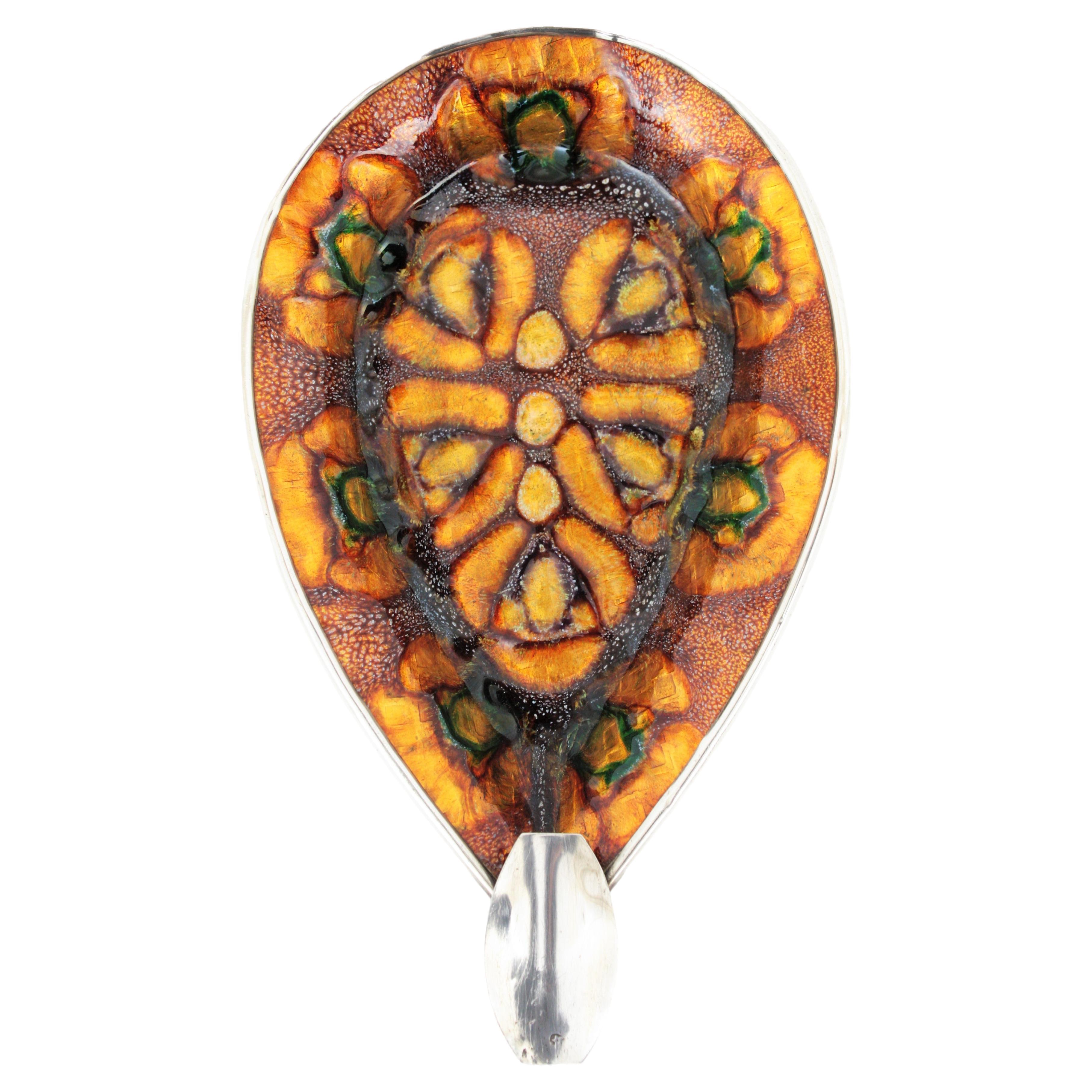 Sterling silver and enamel tear drop ashtray with silver flecks, Spain, 1950s
Beautiful sterling silver tear drop shaped ashtray covered by enamel with a floral design in orange, yellow, amber and green colors and silver flecks inclusions.
Useful as