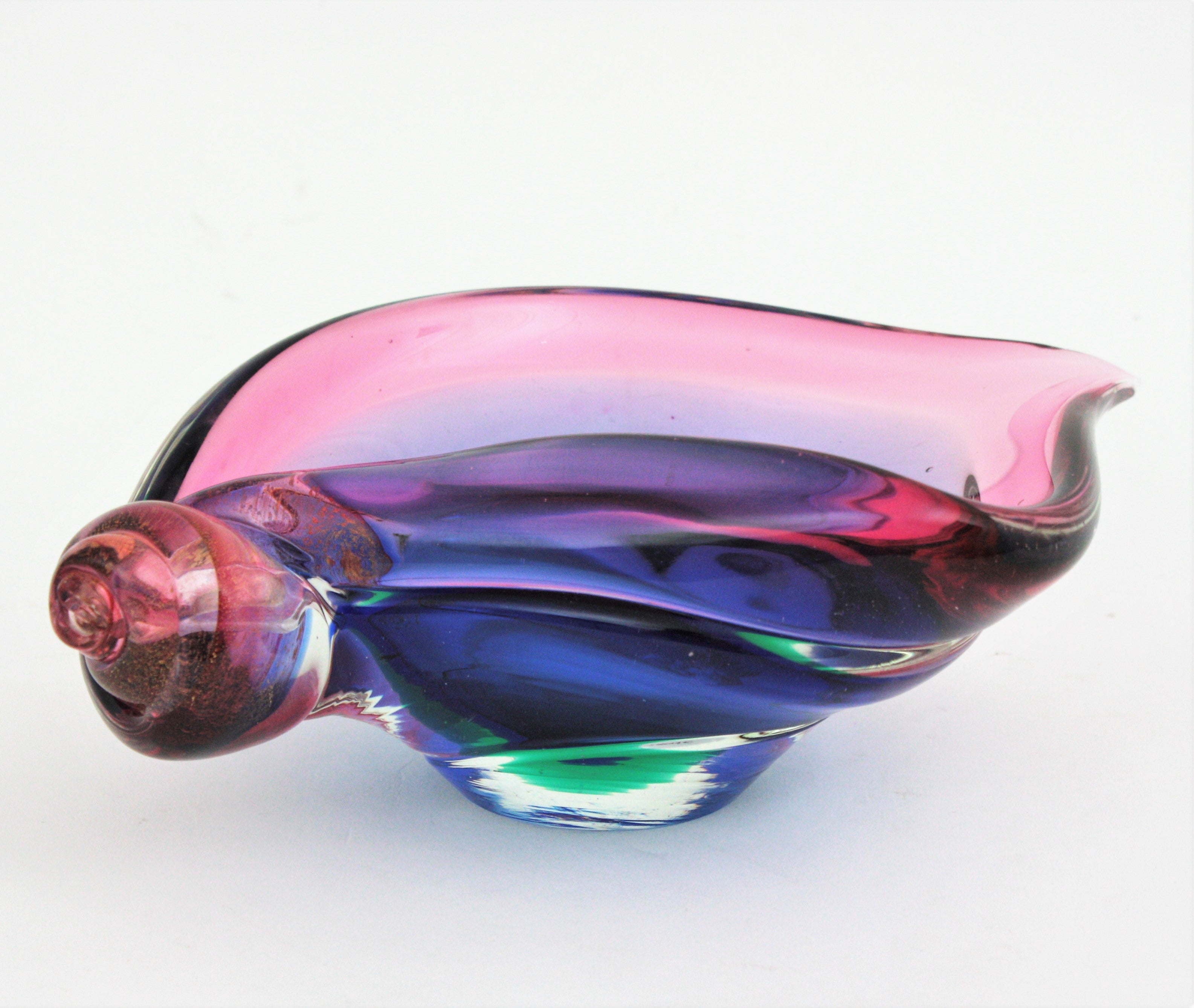 One of a kind hand blown Murano shell bowl centerpiece in shades from pink to blue. Attributed to Seguso, Italy, 1960s.
This beautiful shell bowl has pink, purple and blue glass cased into clear glass with Sommerso technique. It has an elegant and
