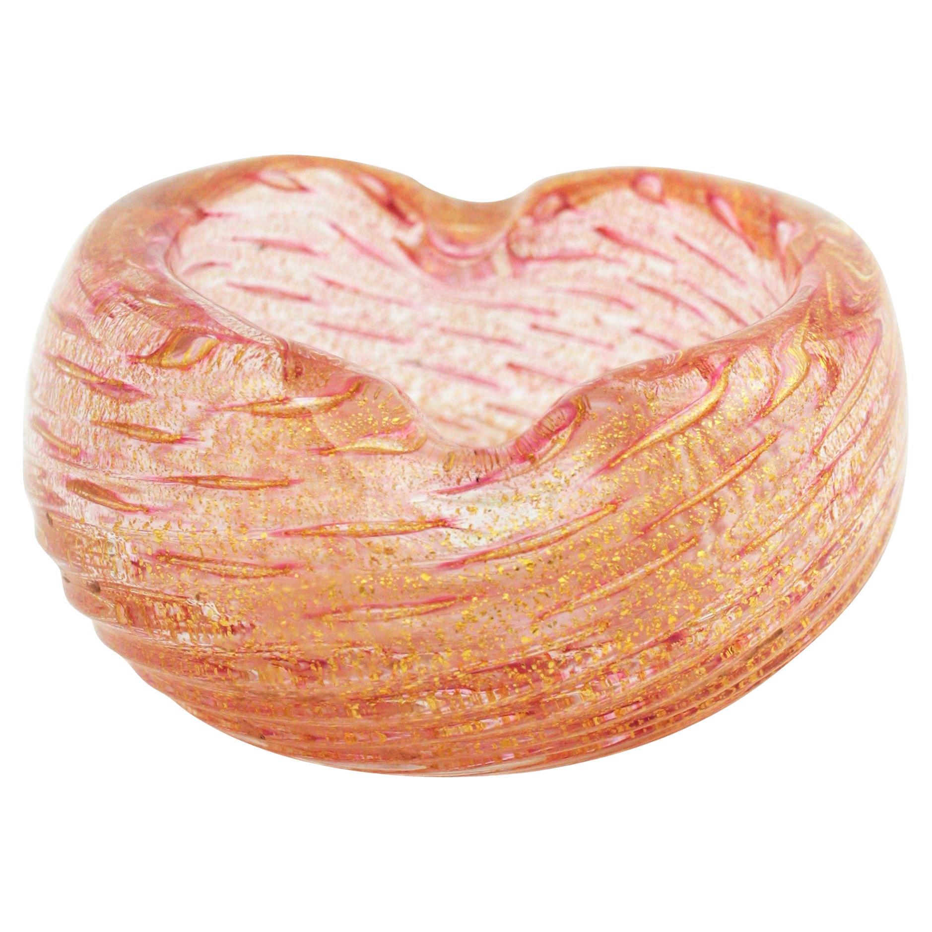 Amazing scalloped Murano pink blown glass ashtray or bowl with aventurine gold and copper flecks. Attributed to Barovier e Toso, Italy, 1950s.
It has controlled bubbles and a scalloped and swirl design and the copper and gold flecks give a luxury