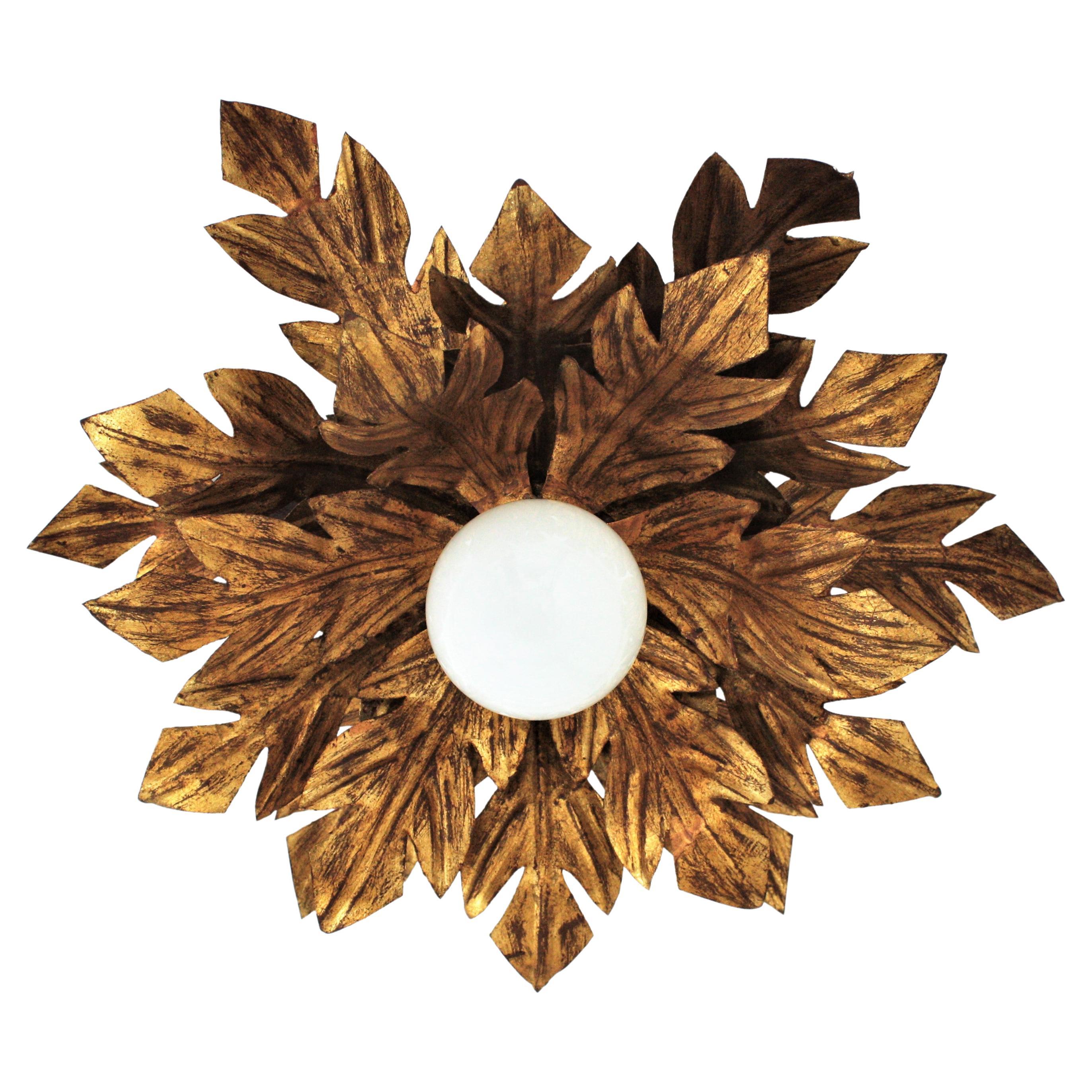 Spanish Sunburst Foliage Flower Light Fixture in Gilt Metal, 1950s
Gorgeous Hollywood Regency hand-hammered iron leafed flower burst flushmount or sconce with gold leaf finish. Spain, 1950s.
Three layers of leaves with a realistic distribution like