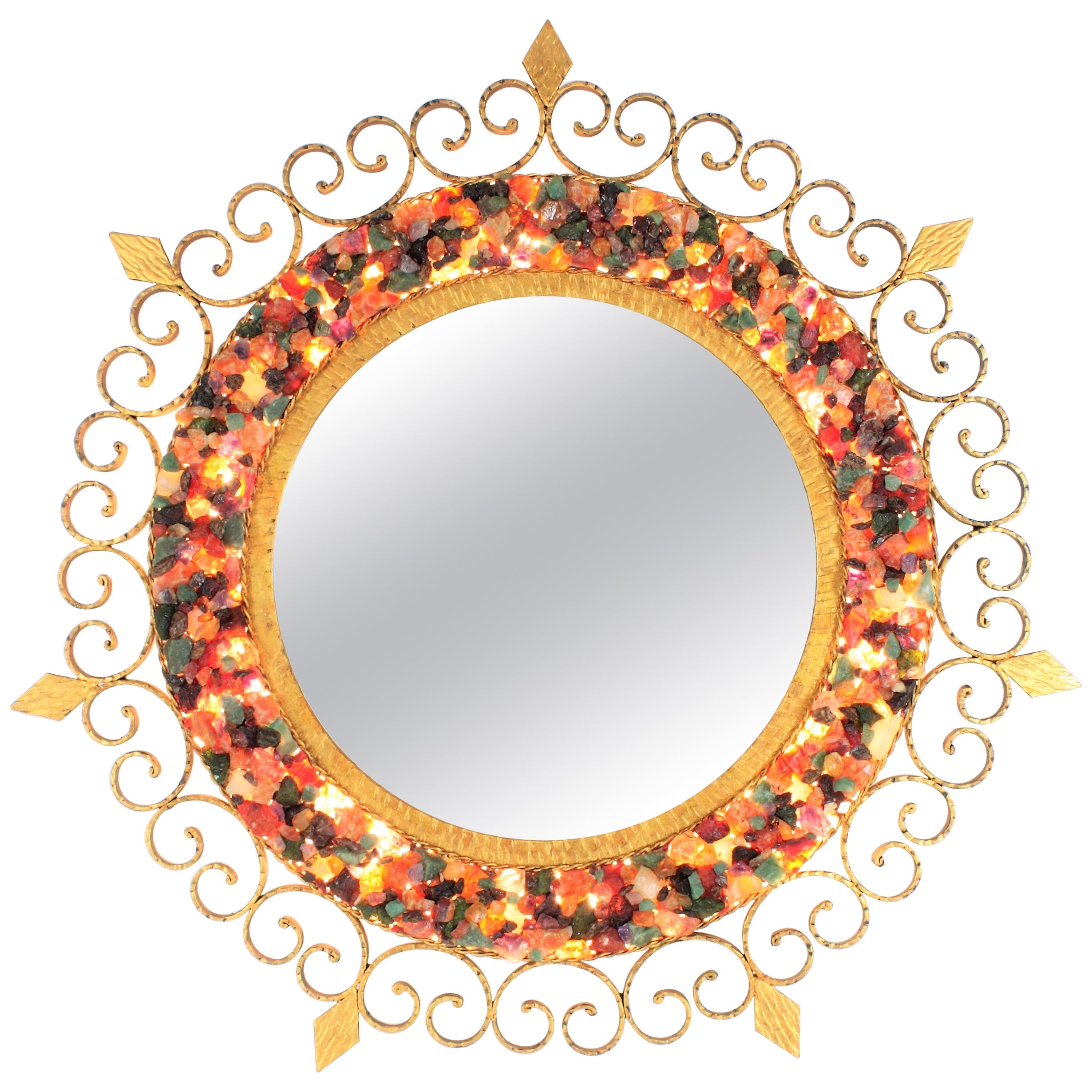 Beleuchteter Spiegel mit Sonnenschliff, Edelsteinrahmen, vergoldetes Eisen, Spanien, 1960er Jahre.
Außergewöhnlicher Spiegel aus vergoldetem Eisen mit Retro-Beleuchtung, umrahmt von einem Mosaik aus farbenfrohen natürlichen Edelsteinen.
Der mit
