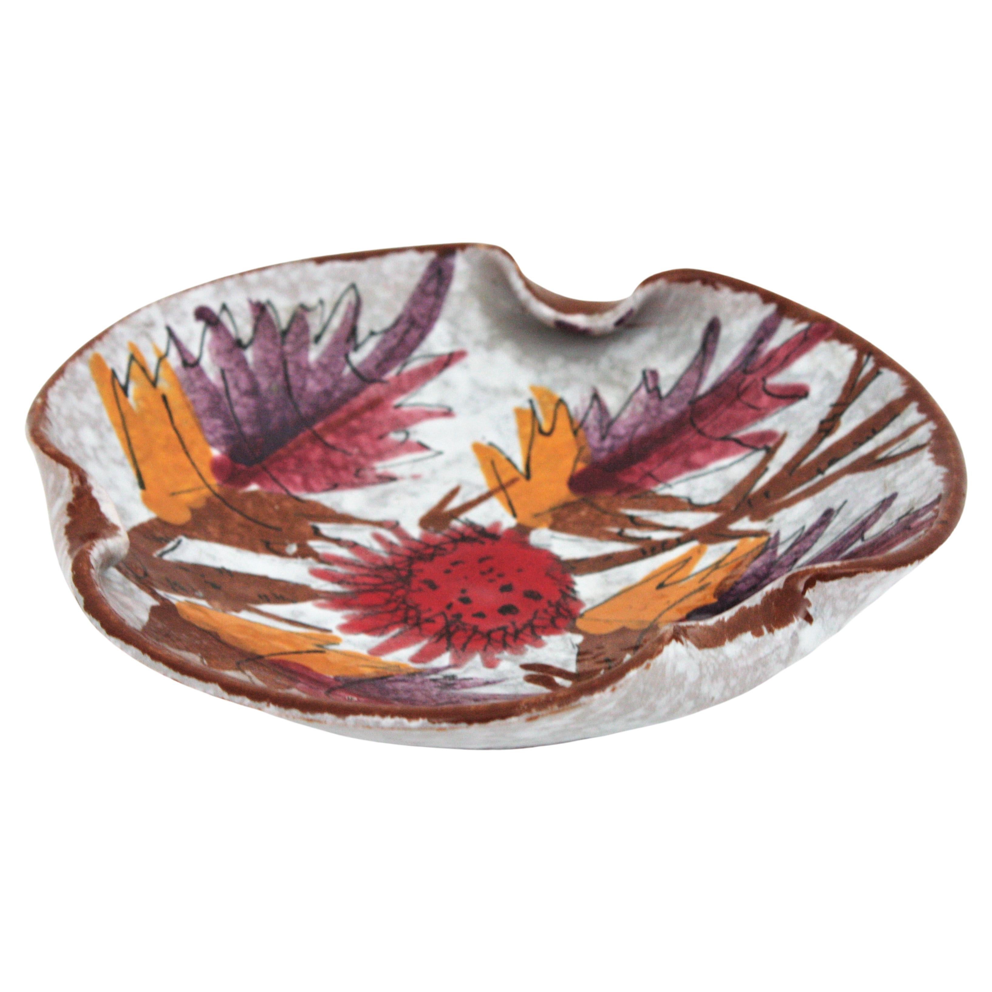Beautiful decorative bowl, ashtray or videpoche in multicolor glazed terracotta. France, 1950s.
It has an eye-catching design with leaf decorations in shades of pink, purple and orange on a white background.
It has cigarrette holders to use it as