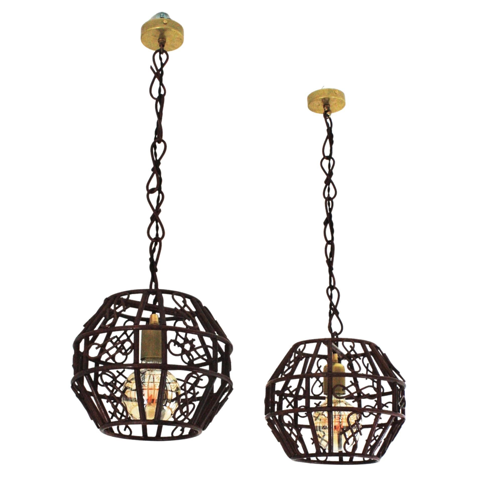 Pair of Rattan Pendants or Lanterns with Chinoiserie Accents, France, 1950s-1960s.
Pair of Mid-Century Modern rattan hanging lamps or lanterns accented by Oriental Details. 
These handcrafted ceiling lamps feature rattan pagoda shaped lanterns
