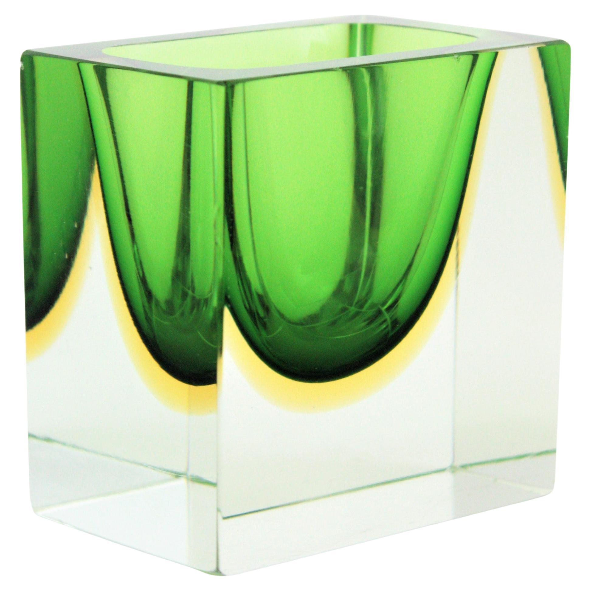 Faceted Sommerso square murano art glass block bowl. Attributed to Flavio Poli, Italy, 1950s.
Materials: Murano glass, Faceted.
Colors: Green, yellow, clear glass
Eye-catching squared block cut faceted bowl or ashtray in green and yellow color