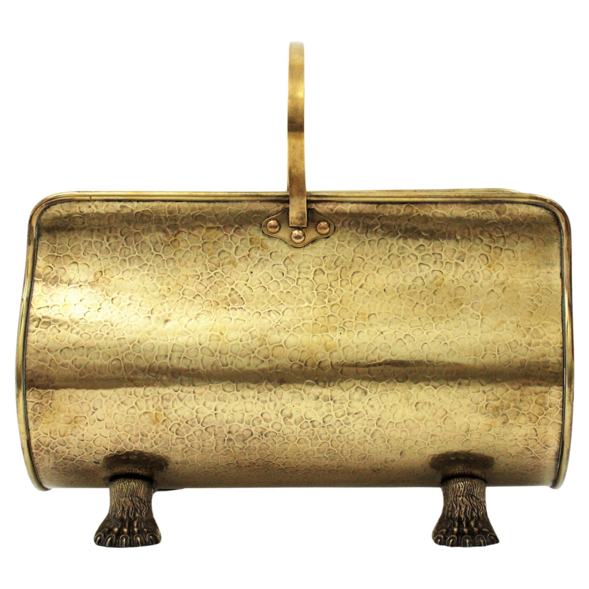 Eye-catching footed brass fireplace log holder / basket with paw feet and handle. France, 1930s.
This Regency style basket has hand-hammered marks thorough and it stands up on four claw feet.
This brass basket has multiple uses: Use it as a log