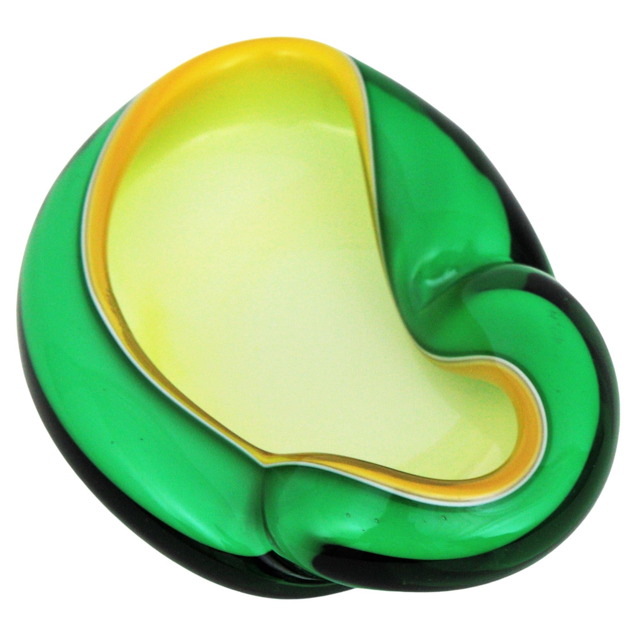 Eye-catching and colorful Murano hand blown green, yellow and white Italian art glass bowl or ashtray with folded rim. Attributed to designer Alfredo Barbini.
This asymmetric and biomorphic bowl has amazing shapes and colors using the Sommerso