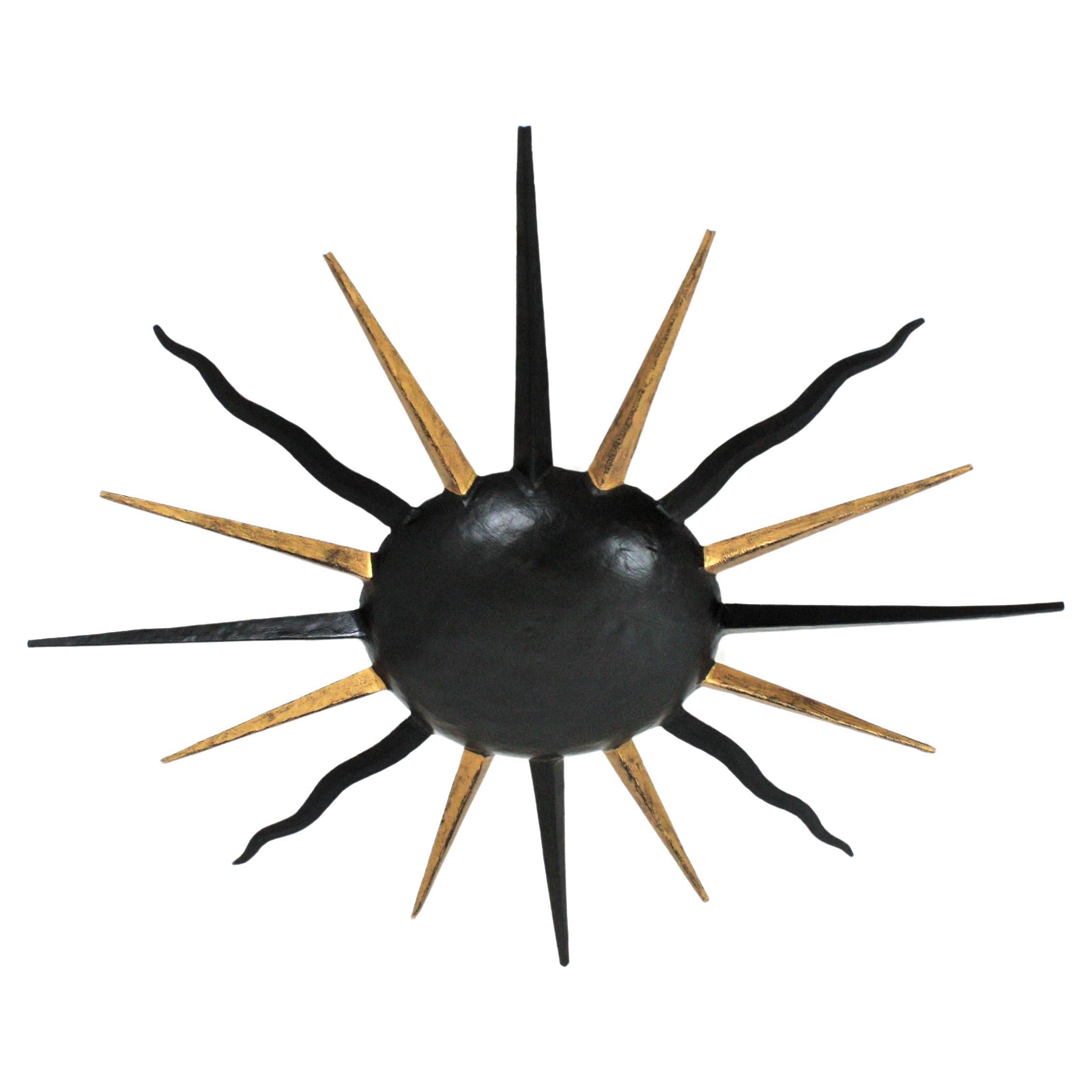 Outstanding hand forged gilt wrought iron large sunburst starburst flush mount in the manner of Gilbert Poillerat. France, 1940s.
This light fixture has an eye-catching starburst design. Entirely made by hand in wrought iron and finished combining