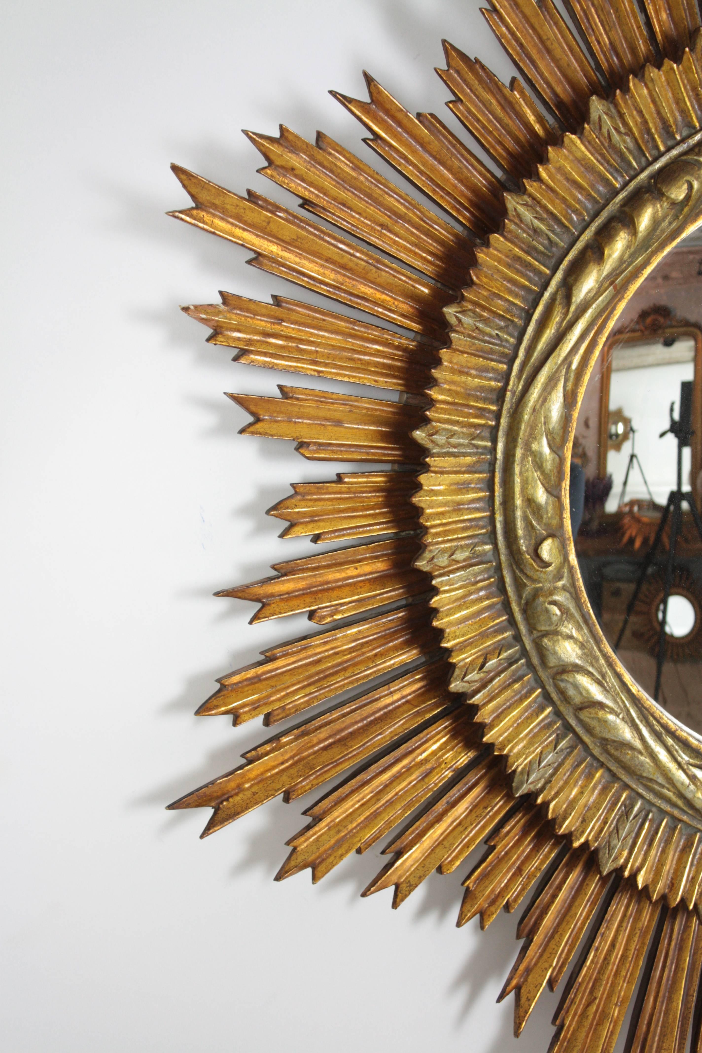 Spectacular Spanish hand-carved mirror, with a gold leaf finish.

The mirror has two layer frame with beautiful carved details and two tones of silver and gold leaf finish. Original fish eye mirror.

Excellent condition, lovely patina.