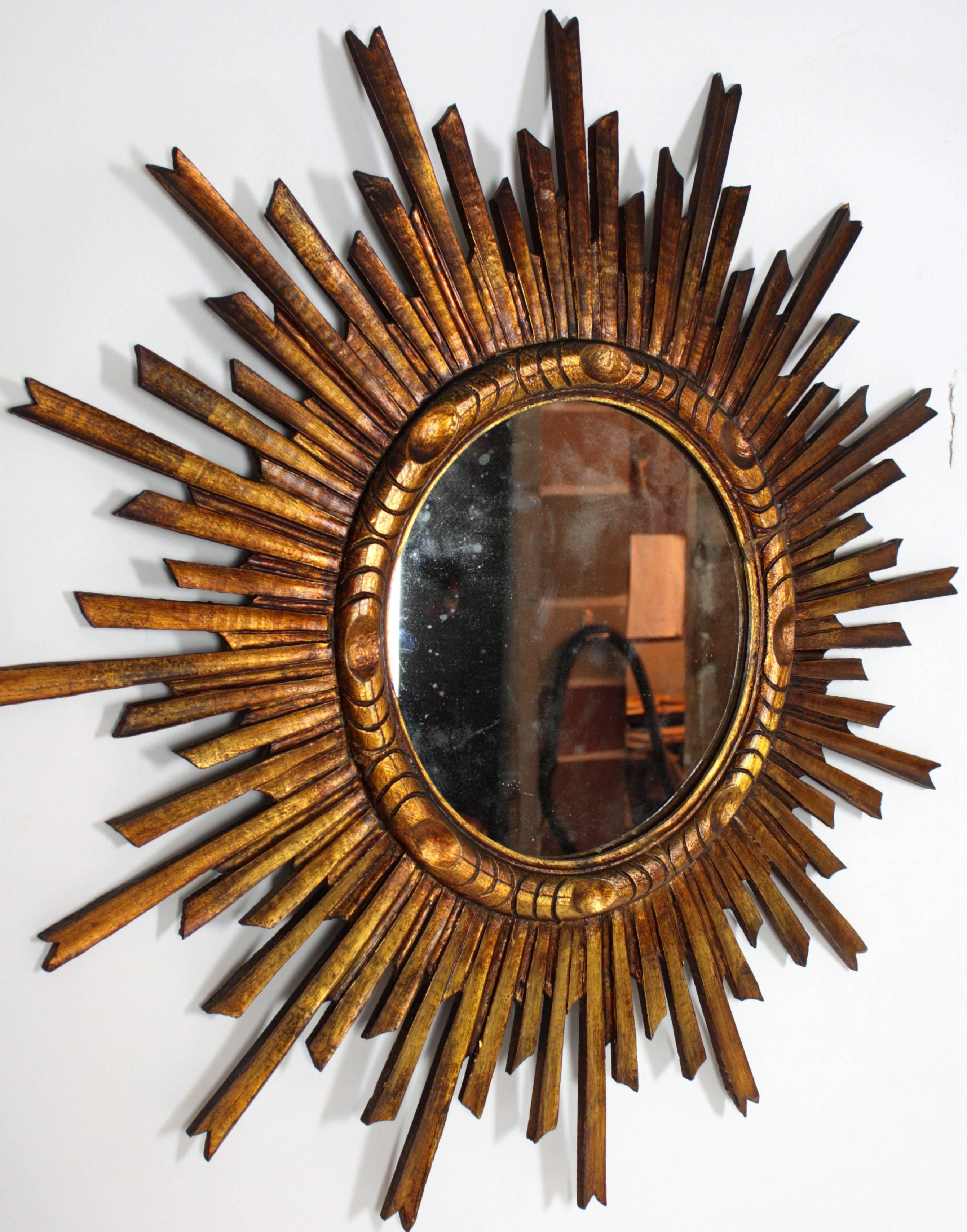 Gorgeous Baroque style sunburst mirror hand carved with gold leaf finish.

Beautiful patina, Spain circa 1900.