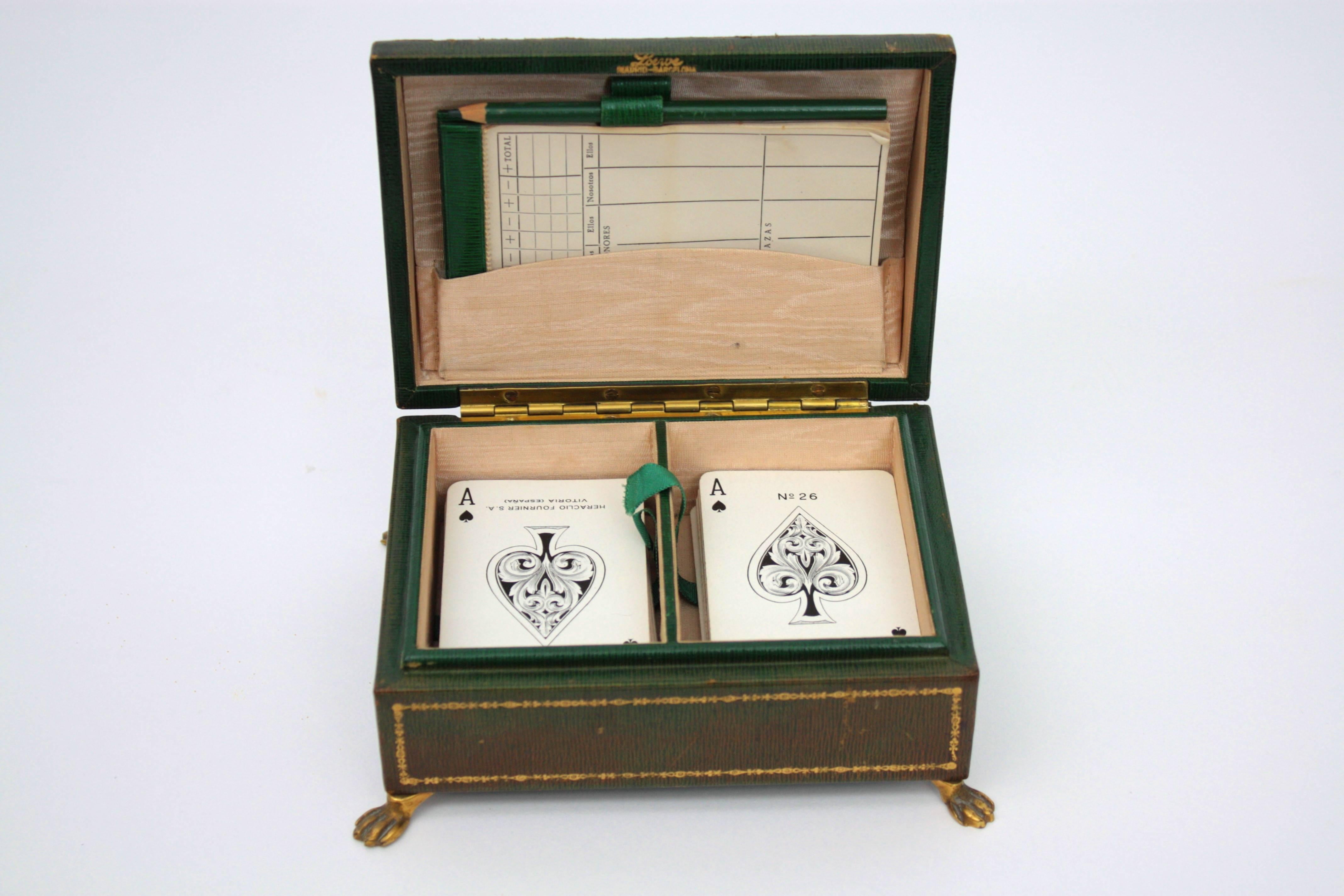A fine Loewe leather cofre playing cards set. Madrid, Spain, 1920s.
Double deck of 52 cards with two notebooks.
The cofre is made in green leather with engraved gold patterns and it stands up on brass claw feet.
Perfect as a gift idea.
Measures: