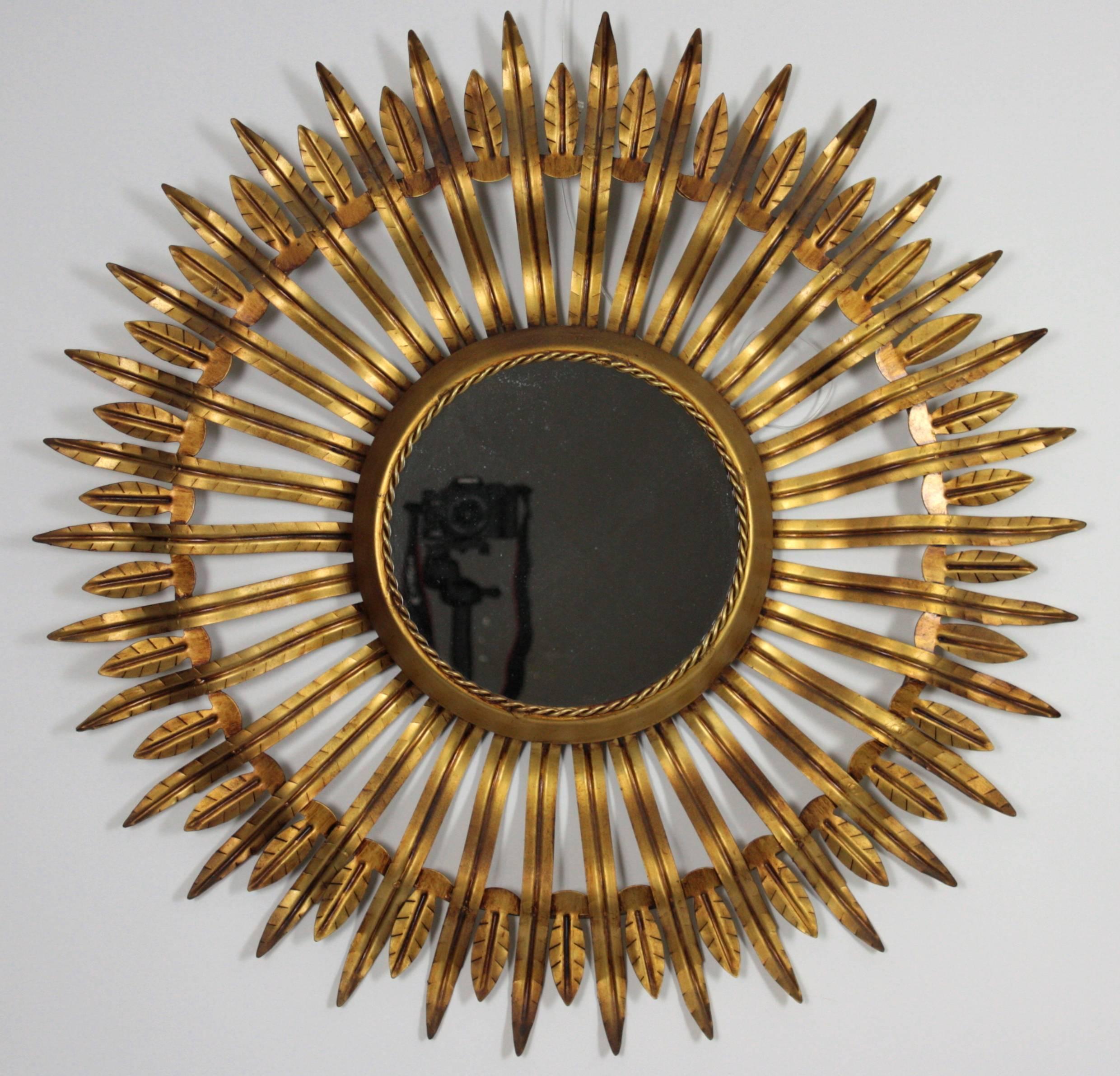 Spectacular and highly decorative gilt iron sunburst mirror. 
Spain, 1960s.

Glass Diameter: 23cm

More sunburst mirrors are available in our shop:
Please, kindly check our storefront.