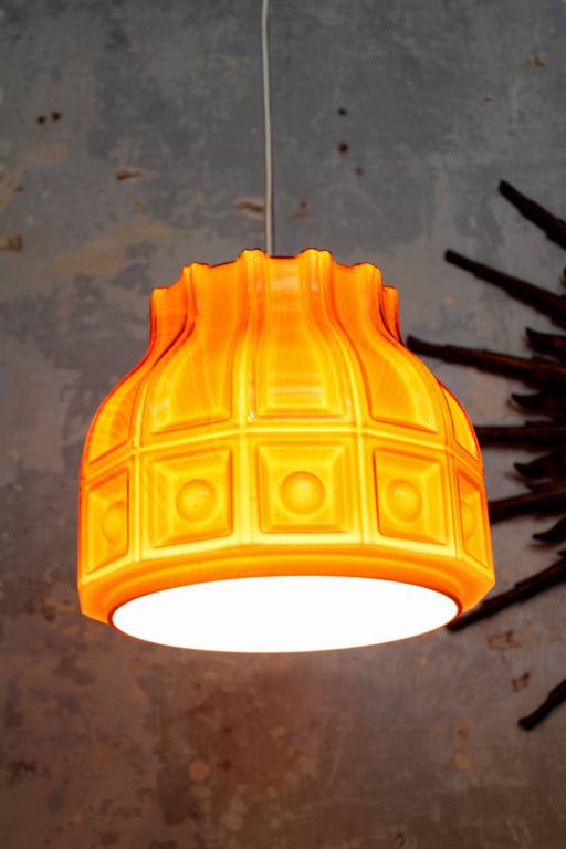 Beautiful Scandinavian Modern glass pendant lamp in amber color. Sweden, 1960s.
Double layers of glass, white in the interior part and amber outside, that makes an spectacular warm light.Designed by Helena Tynell for Flygsfors. The lamp is in