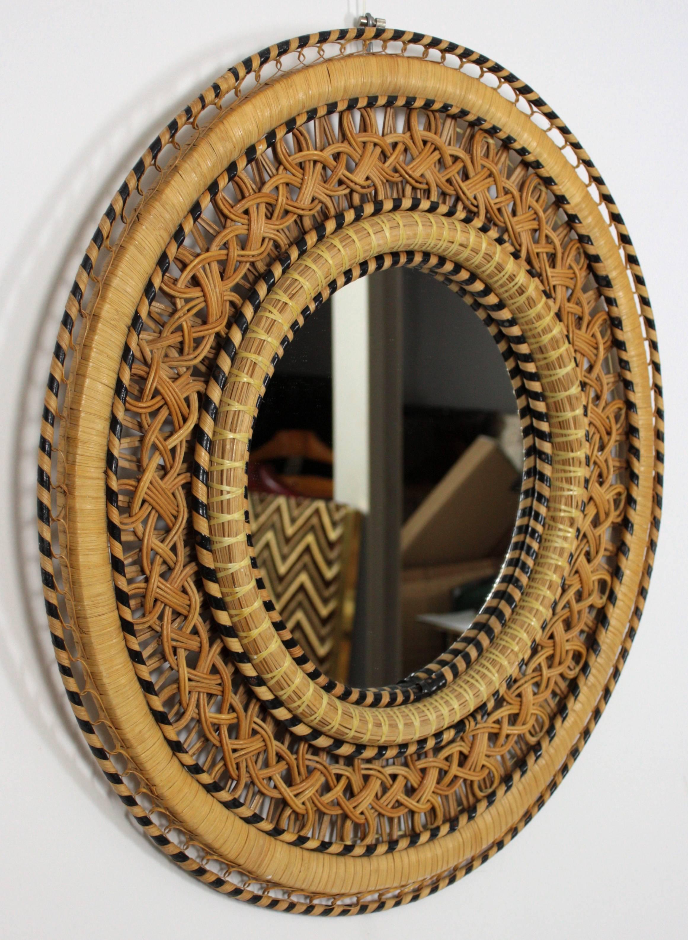 Spanish woven wicker mirror with an amazing handcrafted rattan and wicker work combining different colors and creating a beautiful visual effect,
Spain, 1970s.

Gorgeous to place it alone or creating a wall decoration with other wicker or bamboo