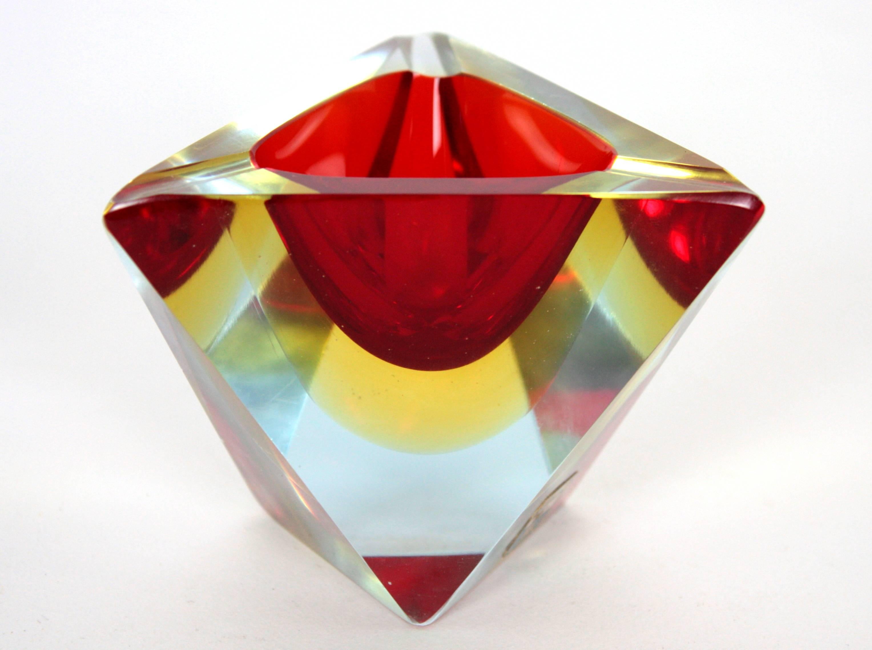 Dreieckiger Aschenbecher aus facettiertem Muranoglas von Sommerso. Wird Flavio Poli zugeschrieben. Italien:: ca. 1950er Jahre. 
Rotes und gelbes Glas in Klarglas eingefasst. 
Er kann auch als kleiner Ring oder Schmuckschale verwendet werden.