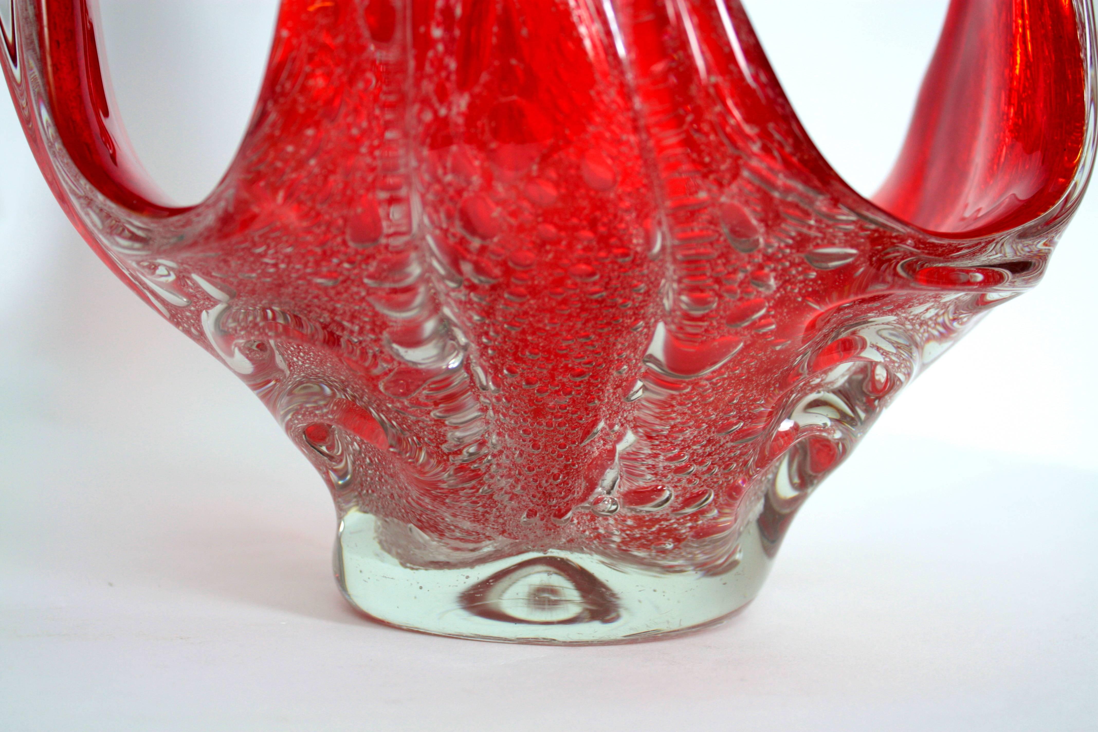 Spectacular Murano glass vase or centerpiece in a vibrant red color cased into clear glass. Hundreds of controlled bubbles with the "Pulegoso" technique.
A highly decorative piece with amazing color and shapes,
Italy, 1950s.

This