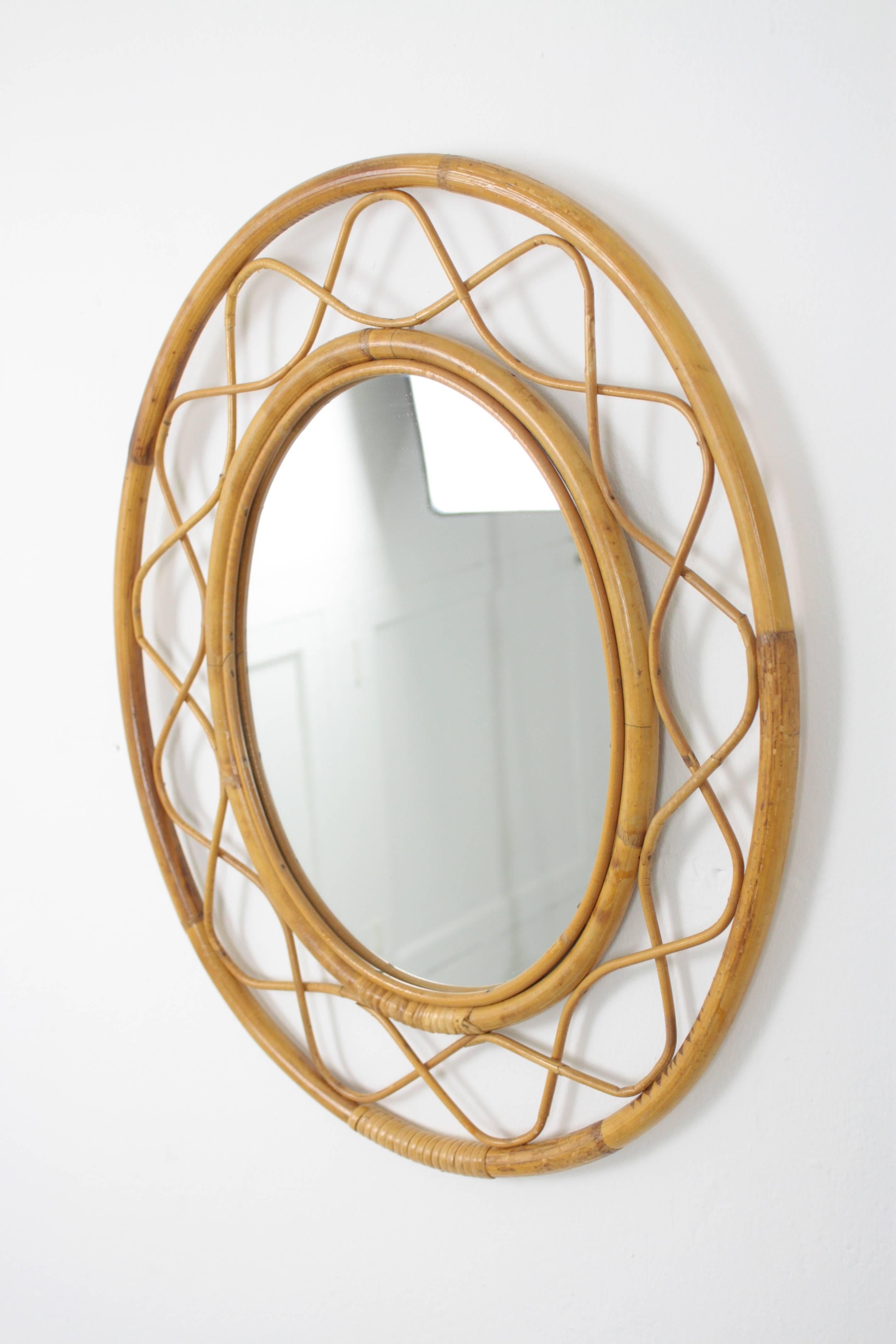 Beautiful handcrafted bamboo and rattan oval mirror with all the taste of the Mediterranean coast style. In the style of Jean Royère.
France, 1960s.

Glass dimensions: H: 33 cm x W: 26 cm.

Gorgeous to place it alone and also beautiful