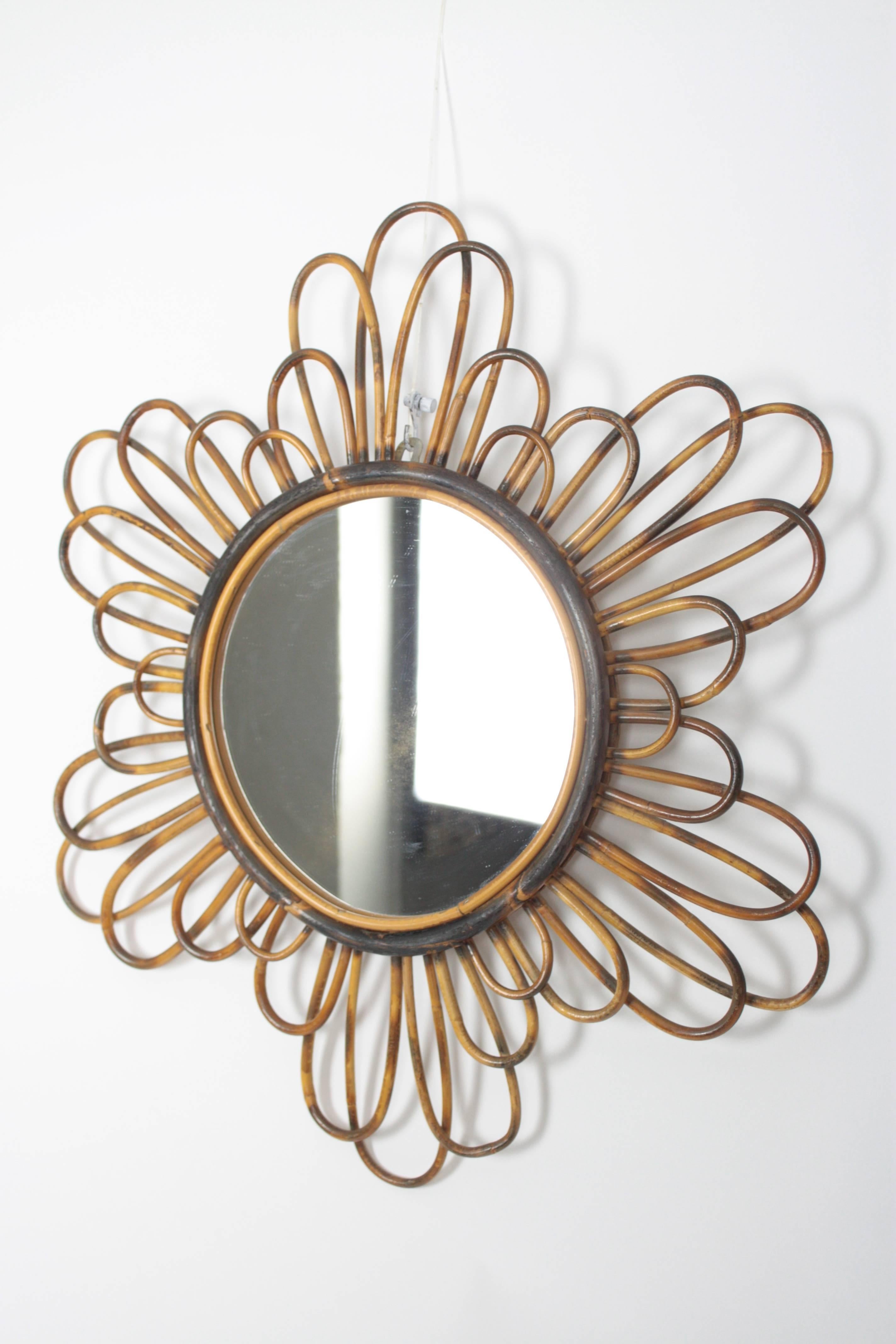 Lovely French riviera flower burst mirror handcrafted in bamboo or rattan and decorated with pyrography accents, 
France, 1960s.

Beautiful piece to place it alone or creating a fresh and Mediterranean wall decoration with other bamboo and rattan