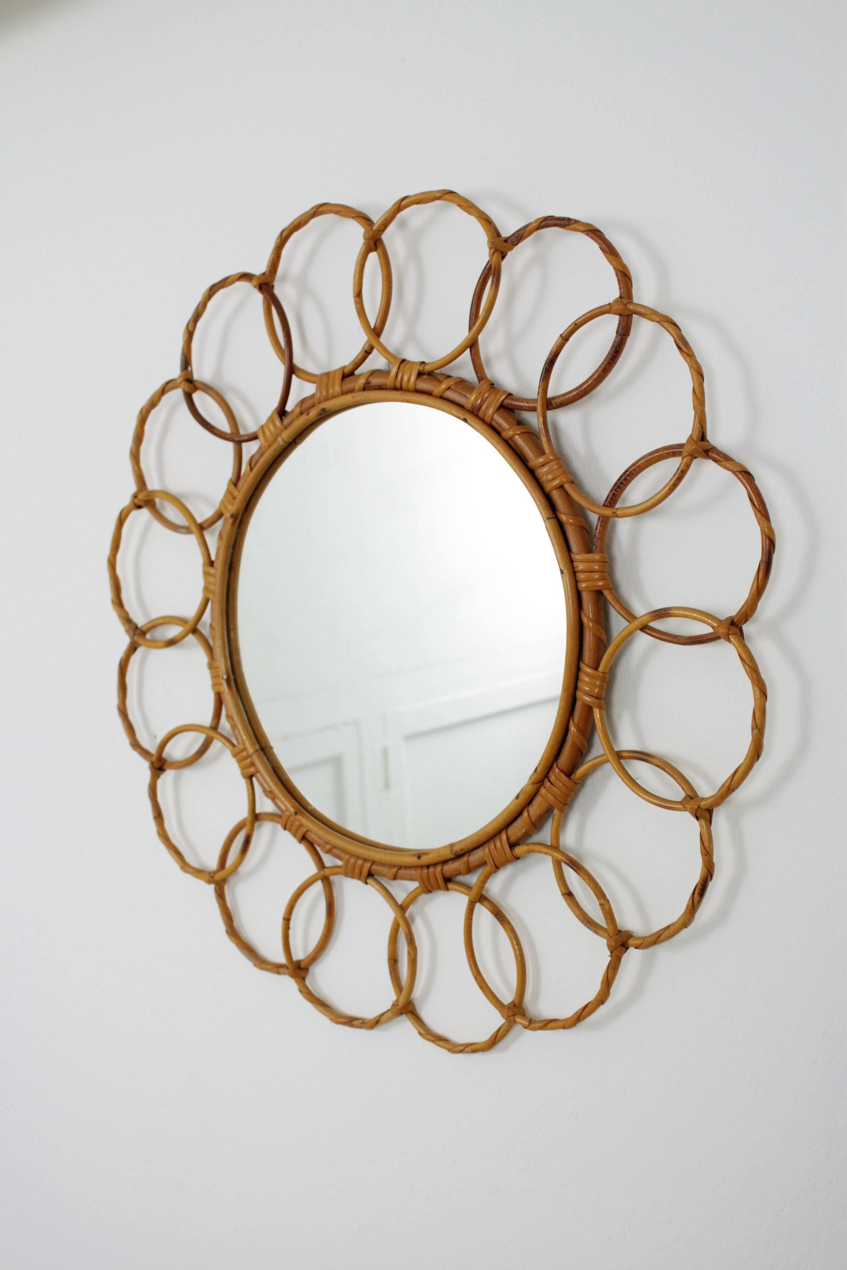 A highly decorative Spanish hand-crafted bamboo and rattan mirror framed with circles. Lovely to place it alone or to create a wall decoration with other bamboo and rattan mirrors,
excellent vintage condition,
Spain, 1960s.

Beautiful to place