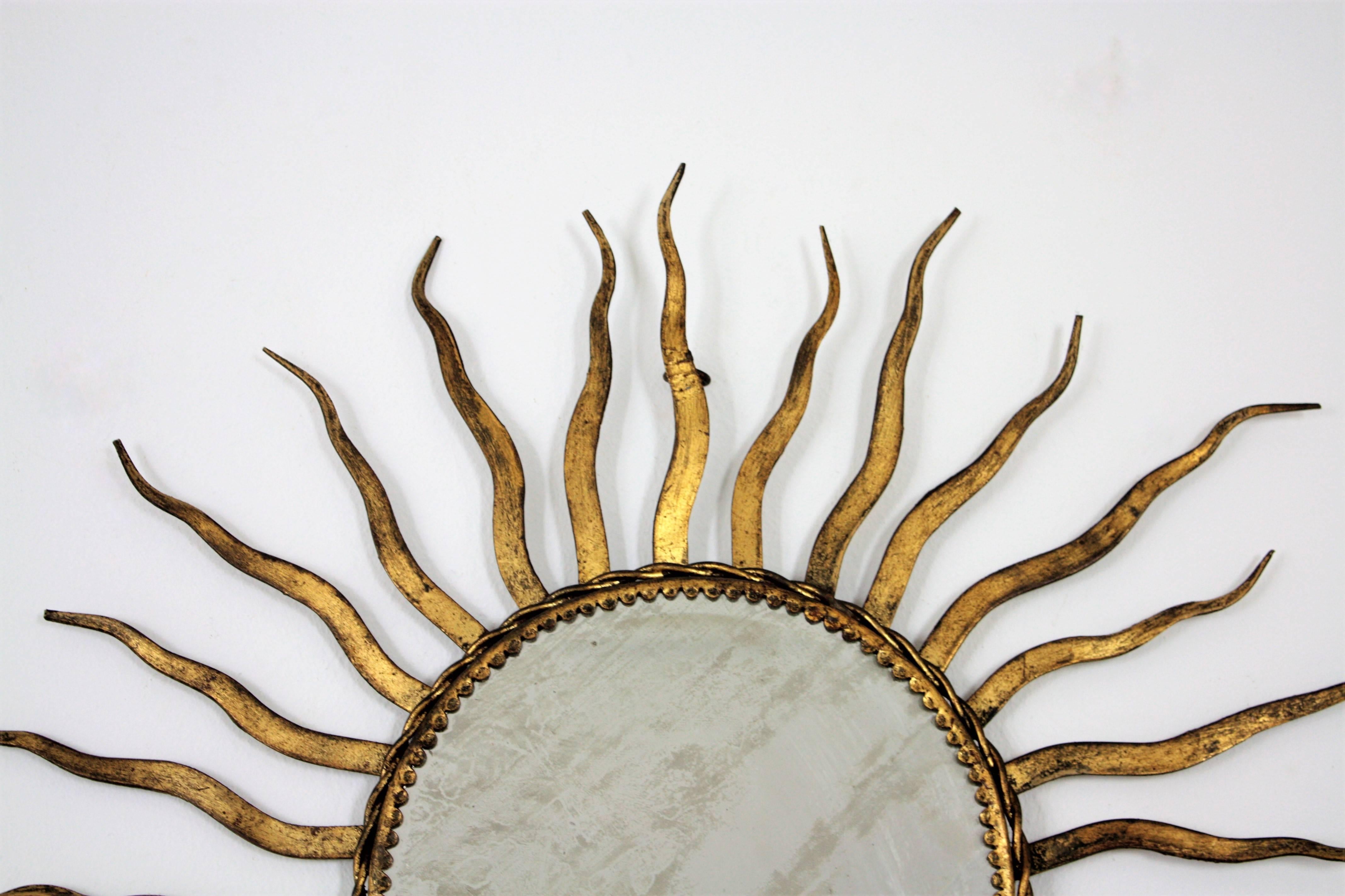 Beveled French 1950s Wrought Gilt Iron Sunburst Mirror in the Style of Gilbert Poillerat