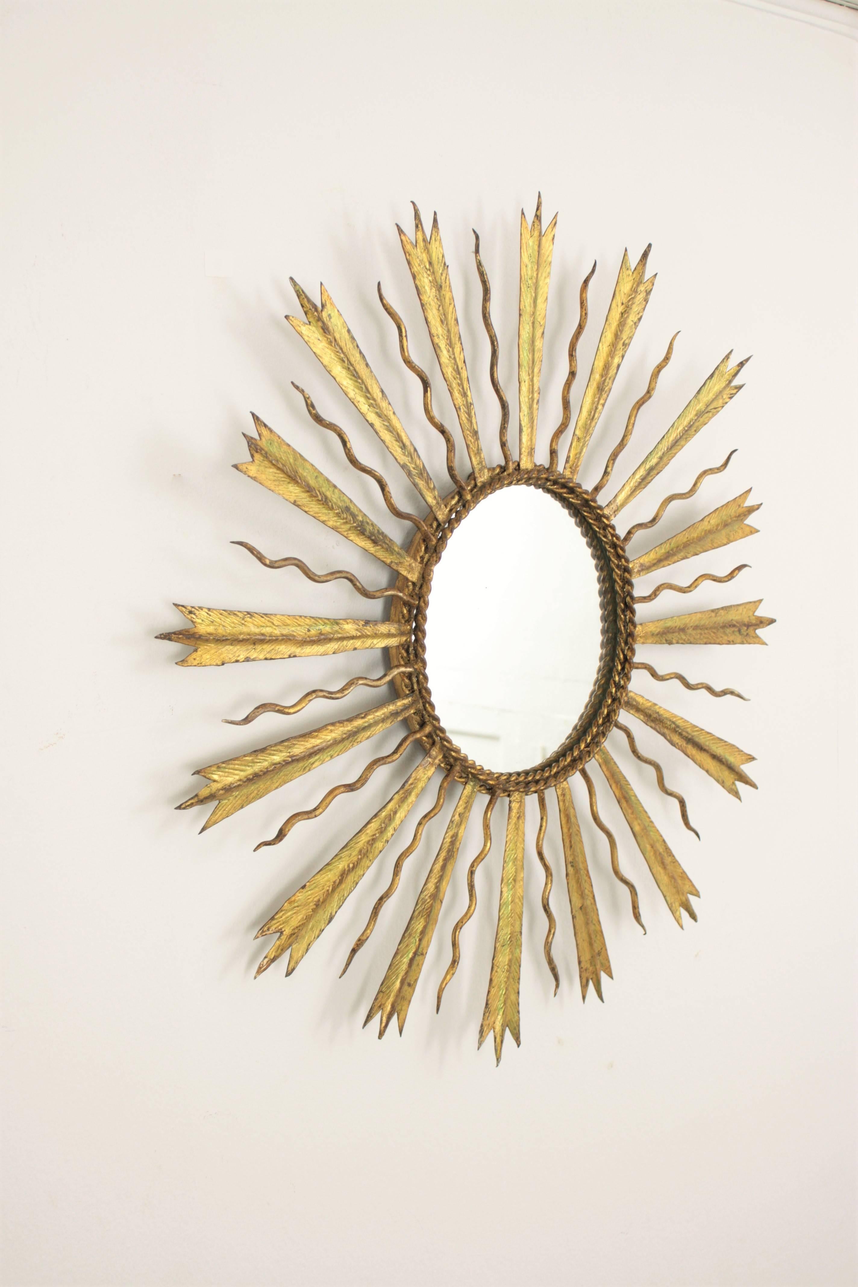 Lovely hand-hammered gilt iron sunburst mirror with combined beams in the style of Gilbert Poillerat,
France, 1930s.

Beautiful to place it alone or to create a wall decoration with other mirrors in this manner.
Avaliable a huge collection of