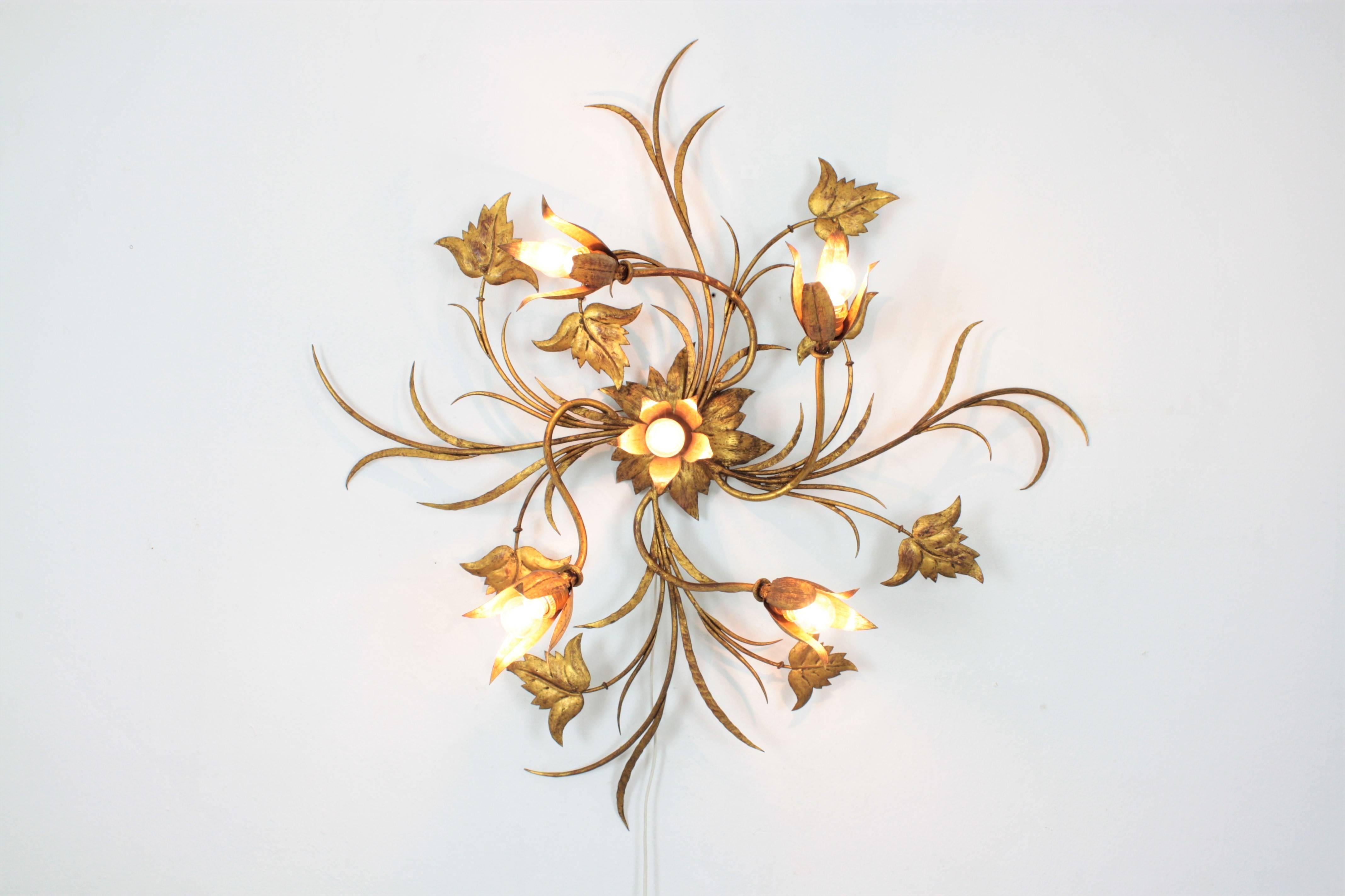 Magnificent hand-hammered wrought iron five-light wall sconce, ceiling sconce or wall decoration with gold leaf finish. This sconce has a naturalistic design with leaves and flowers in the style of Art Nouveau. The lamp has floral bulb holders, a